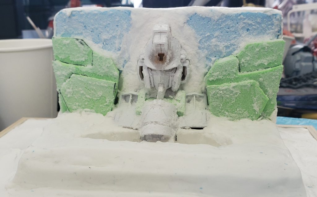 それから紙粘土で地面を作りつつ肩を１回作り直しました。その上から重曹を塗ってみたのですが下の色が透けてしまっていたので、白系の塗料を下地として肩などに塗りました