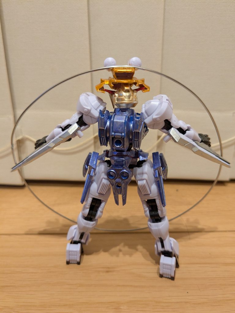 バックショット。頭は諏訪子の髪をイメージしてイエローゴールド。帽子は固定フレームの腰パーツと肩関節を利用し、メタリックオレンジで塗装しました。メインアンテナを横の空きスペースに差し込んで固定してあります。体とスカートはガンダムメタリックバイオレットです。エアリアルのパーツだけでスカートをも少し増やしたかったので、ガンビットをいくつか使用しました。諏訪子が持っているリングは、家にあった針金を使用しました。