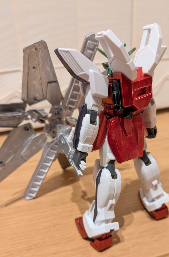 傘を置いてのバックショット。背面も前面と同じイメージで塗装。バックパックは、エックスの内部バックパックをメタリックブラック、外部のディバイダー用バックパックはロイヤルメタレッドにしました。後ろから傘の芯を見るとよく分かりますが、傘の芯はビームマシンガンの頭を切ってディバイダーの持ち手部分に接着し、おしり部分にビームサーベルの柄を付け、そこを持たせています。