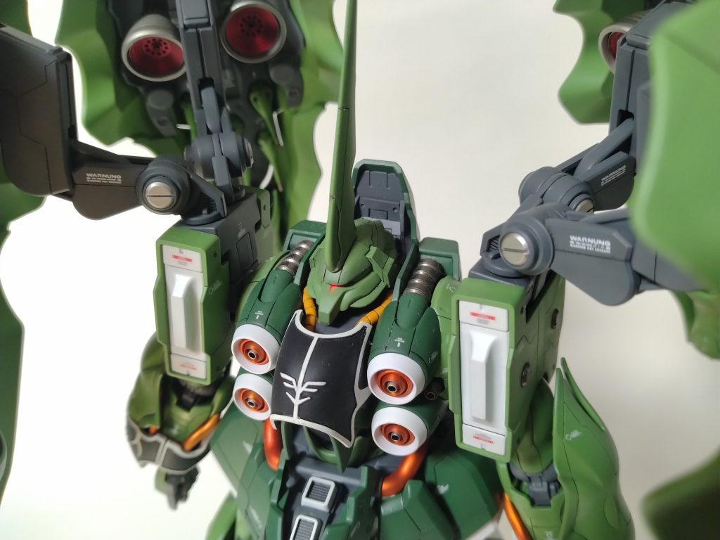 頭・首周りです。トサカはプラバンで大型化し、モノアイには電飾を仕込みました。モノアイスリットもゲルググの顔を参考に切れ込みを入れています。首は2mm程度延長、襟周りはプラバンでディテールを追加しています。肩のパイプもメリハリをつけたかったのでメタルパーツに換装しました。