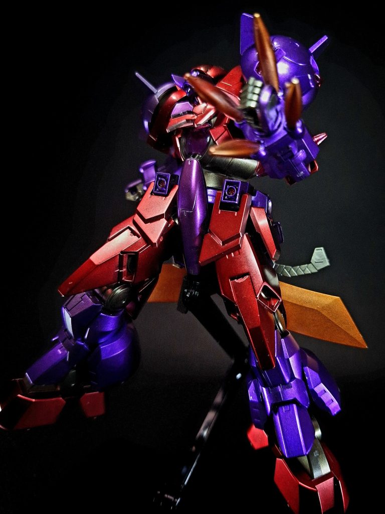 特殊機能トランザムシステム (TRANS-AM)機体の内部に蓄積された高濃度圧縮粒子を全面開放することで性能を向上させるシステム。本機では同時に頭部のバイザーが下降し、センサー類を眼前の敵一体に収束させて集中解析を行う特殊ロックオン機能「一ツ目モード」へと変化する。一度睨んだ相手を食い尽くすまでその視線が外されることはない。GBNではこのシステムが使用できるかどうかはそのガンプラの出来に左右されるというが、本機の完成度は高いため問題なく使用可能。
