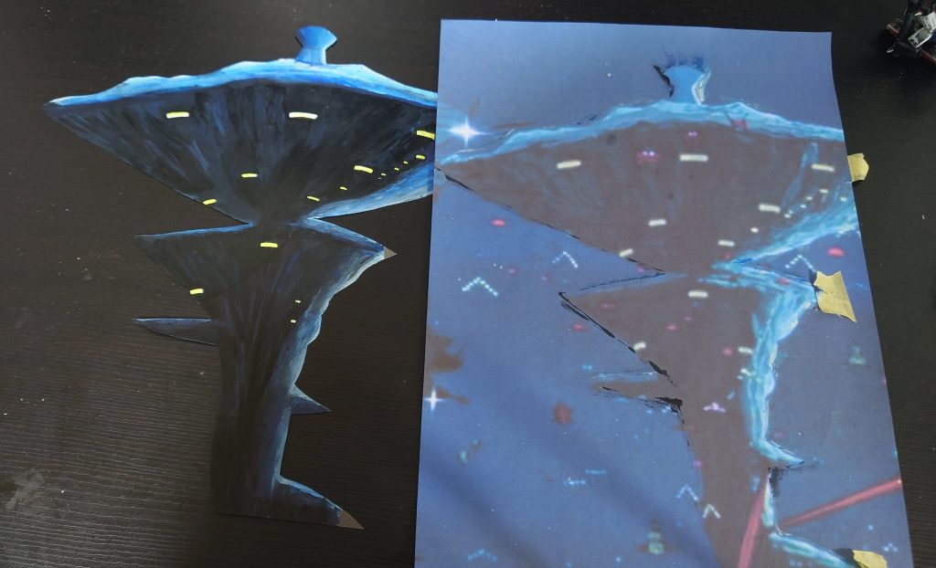 透明のプラ板にア・バオア・クーを筆で描いてます。