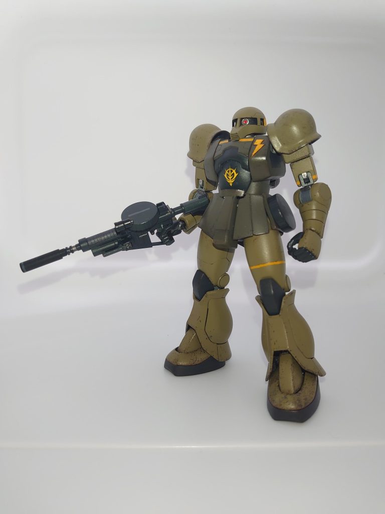 改造にあたり、胸部アーマーのみザクIスナイパータイプから流用しました。頭部はプラ板とパテで高須クリニックしました。腹部は動力パイプが無くなった分ライザップされたように感じたのでプラ板とパテで盛って少しだけリバウンドさせています。マシンガンはF2に付属していたものを拝借。プラパイプでサプレッサー的なものを作ってみました。腰の予備マガジンはネオジム磁石でくっついています。