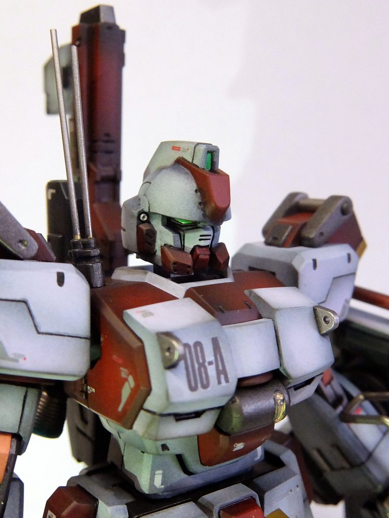 チンガードっている？ロボットやのに。これのせいで顔が大きく見えてバランス悪なってるとこもありそうやし、チンガード切ってアゴに流用。 アンテナも頭に付けんでもええやろ、という事で肩に。それと、目が大きすぎるかな？ 削って細く〜 これで、だいぶ小顔になって、シャープな感じになったかな。 