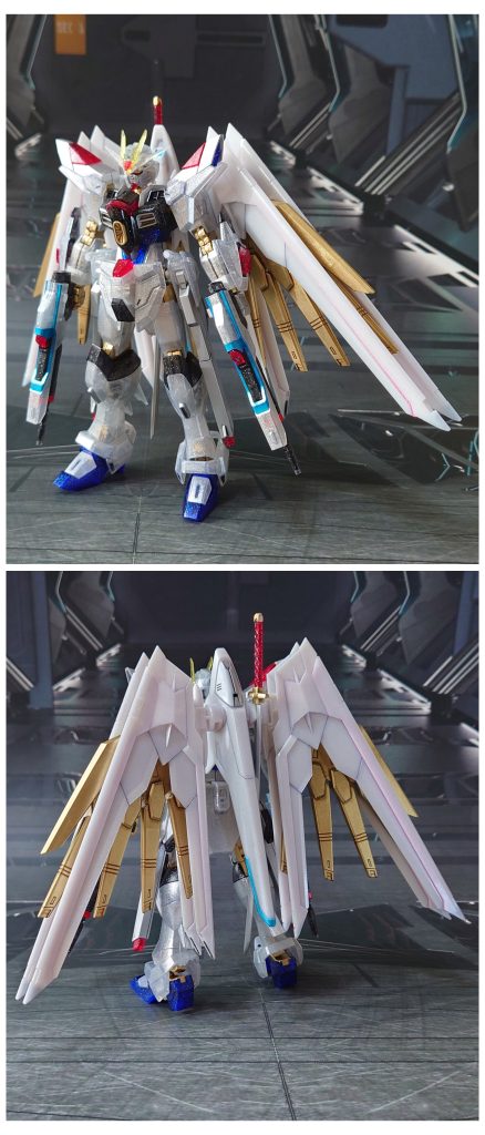 マイティーストライクフリーダムガンダム[リミテッドクリア]の前後ろ。工作は、ゲート痕処理、エッジ尖らせ、パーティングライン・段ズレ・ヒケの対処、面出し、肉抜き穴埋め、市販パーツ貼り付け・埋め込みによるディティールアップを実施。肉抜き穴埋めは首関節裏側に実施。ディティールアップ工作として、襟を斜めに削って薄く見えるように整形、脛裏のスラスターに市販パーツを貼り付け、こちらも整形しました。