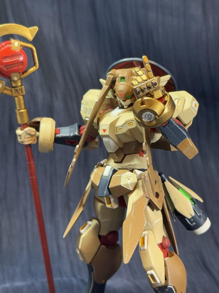 左手には6つの宝石を嵌め込んだゴージャスなガントレットを装備。宝石はそれぞれ「サイコフレーム」「DG細胞」「ゼロシステム」「サテライトシステム」「月光蝶」「AGEシステム」の6つの能力を持ち、それらの力を合わせて指パッチンする事によりMAP上に存在するユニットをランダムに半分に減らせるが、敵味方問わず、自分も含むのでなんとも使えない装備。魔法使いだから握り手は変だし、ただの平手ってのも味気ないし丁度良い左手首が無く、左手首に何か表情を持たせたかったのでイタズラしてインフィニティガントレットっぽいものにしました。グリモアの左手首を加工して指パッチンしそうな表情に変えてます。