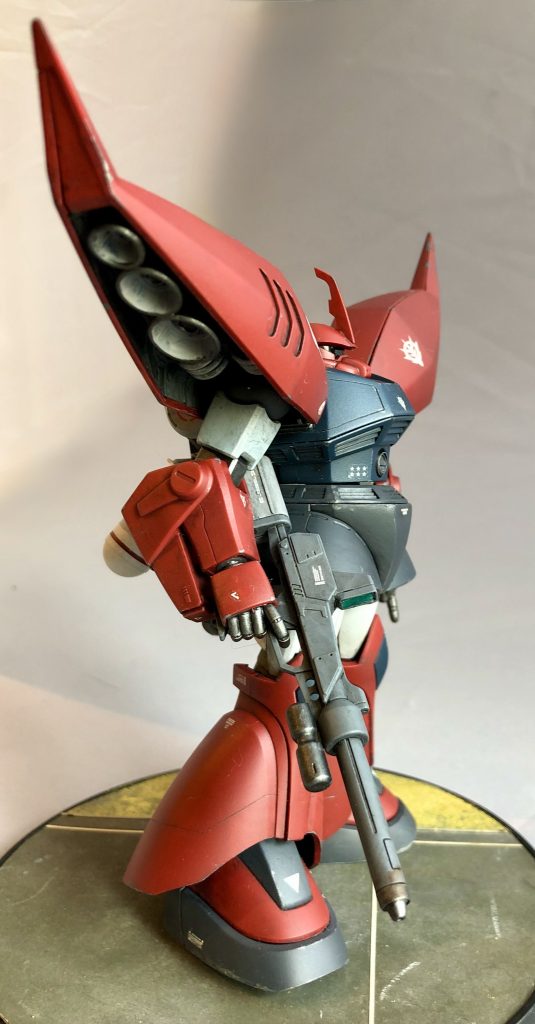 主な改主点は下記の通り・肩の接続軸のリブを削り落とし奥まで刺さるように・丸肩関節スリットを下に広げ、脇を締められるように・ショルダー内フタにストッパーを設け、俯角に入り込まないように・腰前面にエポパテを盛って多面体化・全身にしつこくない程度に筋彫り追加と、ここまでは我が家のゲルググ基本工作。で、さらに・左手首を「指さし手」に・ライフルとバックパックのセンサーは付属ホイルシールの上にUVレジンでコート・バックパックにアンテナ追加・頭部アンテナのバンダイフラッグカット・コクピットハッチを市販パーツに置換です。