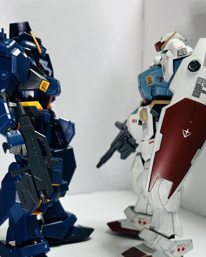 腰部。ベースはパーツ紛失してしまったハイゼンスレイの物をベースに股関節中央ブロックとリアアーマーを手を入れてます。股関節中央ブロックはまずV字モールドを削った上で、クリアレジンとプラ板形状変更、量産機という事でキャラクター性を削る方向性でやってます。リアアーマーは好みでチョバムアーマー付きの方に変えています。バーニア部分のモールドが甘いので全部開口。真ん中の以外は穴開けると貫通状態なのでプラ板でいい感じに埋めました。ハイゼンスレイの股関節は元キットと違って軸接続プラス太腿の回転軸で良い感じ。脚部。ガンダムに仕上げた最大の理由がここにあり。ヘイズル、その派生は基本的に盛られていくために、下半身が貧弱に見えないように足が太めに設計されています。ですんでジムだったら強くなり過ぎる……ガンダムだったらいけるかなって感じです。アンクルアーマーをヘイズル改のものに変えて、スネのカメラをパテとクリアレジンで埋めました。コレは、量産機的なデザインの簡略化と、設定的なコストダウンを狙ってのこと。そもそもコレは設定的に対暴徒用の鎮圧時に使う為のセンサーらしいんで普通なら要らない。