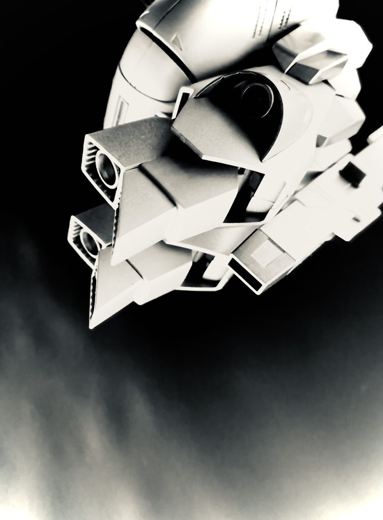 「こっちだ！スカーリ！」　深夜、あまり星も出ていない闇の中、モールダーは丘を登る。この丘の向こうは例の基地だ。私達は、夕暮れ前に行方不明事件のあった街に着くとすぐに聞き込みをした。案の定、その小さな街は、行方不明者の話題。そして、それに劣らず謎の飛行物体の話題で持ちきりだった。それにモールダーが食い付かないわけが無い。「スカーリ！」　丘の上でモールダーが呼ぶ。…基地は逃げないわよ、モールダー。丘を登りきり、身を低くして基地を見下ろす。広大な敷地をぐるりとフェンスで囲まれた何の変哲もない基地。気になるといえば、必要以上に掲げられたティターンズの旗。ほとんどの建物に大きく描かれたティターンズのエンブレムが目立つぐらいかしら。「モールダー、ティターンズの基地よ。ここ」　ああ、そうだね。気のない返事をするモールダーは双眼鏡を覗いている。あれだ。とモールダーが指す先を見ると、滑走路へと向かうミデア輸送機が見える。…こんな夜中に発進するの？建物と同じく必要以上にティターンズのマーキングの施されたミデア輸送機は、その巨体を滑走路へ入れると、ゆるゆると加速を始める。「見ろよスカーリ。滑走距離が長い。…何か重いものを積んでいるな」　グングンと加速するミデア輸送機は、その巨体をやっと持ち上げると暗い空の向こうにその姿を消して行く。隣のモールダーは双眼鏡から目を離していない。私は、ミデア輸送機が消えて行った方角をぼんやりと見ている。　その時だ。私が見ている先、ミデア輸送機が消えて行った空に、複数の強い光が一斉に光ったと思うと、次の瞬間、それぞれがバラバラの方向に動き消えて行ったのだ。「モールダー。今の、見た？」　隣のモールダーは気付いていない。再び空を見上げようとする私に、身を起こしながらモールダーが叫ぶ。「まずいぞ！スカーリ！奴ら、僕達に気付いたみたいだ」　嘘でしょ！立ち上がりながらモールダーの言う方を見る。基地のあちこちにサーチライトが点り始め、サイレンが鳴る。複数のティターンズ兵が、ジープに、トラックに乗って丘を登って来るのが見える。…かなりの人数だ。身を翻しながら、空を見るがさっきの光はもう見えない。「急げ！スカーリ！」　隣を走るモールダーの声が夜の闇の中に響く。