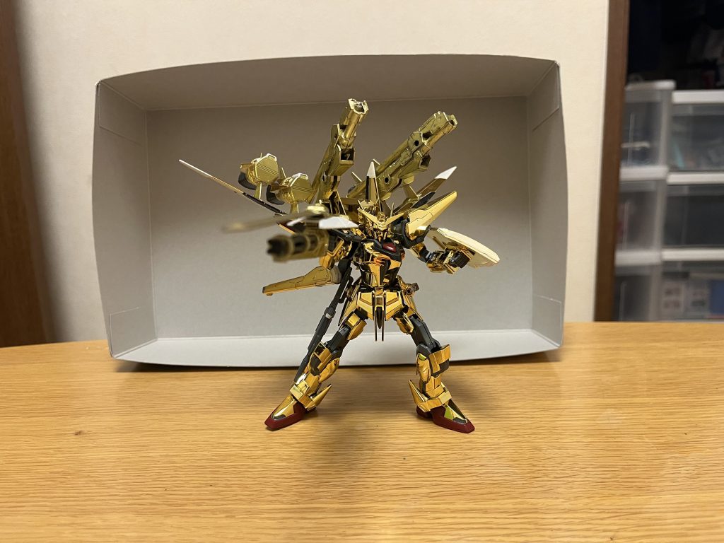 武装改良されたシールドを除けば、本体の武装面は原作と概ね変わらないが、新型バックパック「ホムラ」によって、あらゆる領域で高い攻撃力を発揮可能となっている。M2M5D12.5mm自動近接防御火器頭部に内蔵されているバルカン砲。同時代の地球連合軍で普及したトーデスシュレッケンタイプのオーブ輸入仕様。73J2式試製双刀型ビームサーベル日本刀をイメージした柄の形状を持つ近接格闘用武器。普段は連結したまま1つになっており、分離して2刀流にしたり、ライフルと合体し銃剣にすることも可能。72D5式ビームライフル「ヒャクライ」ストライクガンダムが使用する57mm高エネルギービームライフルをベースにした改良品。フォアグリップの代わりに、ビームサーベル用のマウントラッチが設けられており、ビームサーベルを銃剣としても使用可能とする。不使用時は右腰部に装着される。試製71式防盾アカツキ本体と同時期に開発された実体シールドで、左腕に装備される(右腕にも装備可能)。本装備に関しては本体改修に伴って強化が施されている。ヤタノカガミ部分は、外側のみならず全体に施されており、中心部に至ってはVTP装甲を複合しつつ、その内部装甲は相当分厚くなっており、こちらも陽電子砲を無傷で防げるだけでなく、本体では防げないビームサーベルや対艦刀をも防御可能であり、さらにビーム刃を併用するタイプの実体兵器や対艦刀に関しても、最低でも5撃以上打ち込まなければ破壊不可能なレベル。先端部が尖っており、打突兵器としても使用可能。試製71式ガトリングブレードビームシールド発生装置を内蔵された実体盾に、ガトリング砲と実体ブレードを一体化させた複合兵装であり、右手に装備される(左手でも装備可能)。機体の右側に大きく重心がかかる為に使い勝手が悪いが、本機は出力向上によって本装備を軽々と振り回せるようになっており、加えて左腕にも試製71式防盾を装備しているので、バランスの悪さもある程度解消されている。複合兵装の名に違わず、白兵戦・砲撃戦・防御という様々な場面にて使用可能で、攻防の転換を素早く行える強みを持つ。実体ブレード実体盾の表面先端部に内蔵された実体剣であり、ヤタノカガミと超高品質レアメタルの複合素材によって作られている。並大抵の実体剣はおろかガーベラストレートさえも凌ぐ斬撃力と、高出力ビームサーベルとも互角に斬り結べる耐久性を併せ持つ。さらにヤタノカガミの特性を有している関係上、このブレード自体がシールドとしても機能するだけでなく、通常のビームライフルはおろか、高出力ビームや陽電子砲でさえ、切り裂いて躱す事も可能となっている。実体盾上述の試製71式防盾と同じく、ヤタノカガミとVTP装甲の複合した分厚い特殊装甲で構成された実体式シールドであり、こちらも陽電子砲を無傷で防げるだけでなく、本体では防げないビームサーベルや対艦刀をも防御可能。加えて、本シールドの中央部にはビームシールド発生装置を搭載しており、これを展開する事で、試製71式防盾では数撃までが限界だったビーム刃を併用するタイプの実体兵器や対艦刀をも問題なく防ぎ切るだけでなく、理論上はレクイエムやコロニーレーザーのような戦略兵器ですら2回までは耐えられる(ただし、パイロットの生死とアカツキ本体の衝撃耐性を無視した想定である)。ガトリング砲実体盾の裏面に、実体ブレードと重なるように内蔵された大型ガトリング砲。たった1弾でも、並大抵のMSはおろかFT装甲を持つMSですら撃破可能な威力を誇り、ガトリング砲としての高い連射性能も相まって、実弾耐性の強いPS装甲でさえダウンさせつつ撃破に持ち込めるほど。※ガンバレルストライカーのガトリング砲を使いました。全領域装備「ホムラ」新たに開発された専用オプションであり、その名の通り、地上・空中・宇宙のあらゆる環境に対応可能とする。基礎設計はオオワシをベースとしている為、巨大な主翼・副翼とブースターによる高い機動力をブラッシュアップしているだけでなく、専用兵装「スーパーガンバレル」と大型リニアキャノン2基を追加搭載しており、従来の高エネルギービーム砲2基と併せて、火力面も大幅に強化されている。こちらにも本体同様の複合装甲が施されている。73F式改高エネルギービーム砲ホムラ下部に懸架された高出力ビーム砲であり、砲身には本体同様の複合装甲が施されている。73F式改大型リニアキャノンホムラ上部に搭載された超大型砲2基であり、ゼウスシルエットを基にした新兵装。砲身は、折り畳んだ状態でも、2連装砲として使用可能。そして、リニアキャノン運用時には、砲身を全面展開し、爆薬に陽電子を用いた地中貫通弾または陽電子砲弾を超高速にて射出する事で、大型拠点を一撃で破壊するほどの威力を誇り、PS装甲ですら粉砕可能とする。さらに砲身下部のグリップを展開する事で、精密射撃も可能とする。砲身そのものにも冷却機能が備わっている上、複合装甲の耐久性の高さもあって、基本的に一撃だけで砲身が焼き切れる事はなく、砲身も交換不要となり、結果的に連射性能の向上にも繋がっている。1発撃つだけで莫大な電力を消費するが、本機に内蔵されたハイパーデュートリオンエンジンによって、問題なく使用可能となっている。リニアキャノンの残弾数は最大20発までとなっており、限りがあるとは言え、実用レベルとしては充分に多い。※ゼルトザームアームズのフォールディングデストランチャーを2つ使いました。スーパーガンバレル×4メビウス・ゼロに搭載されていたガンバレルの発展型システム。開発にあたっては、従来ガンバレルのみならず、2世代型ドラグーンシステム等の最新技術が生かされている。このスーパーガンバレルにも、本体同様の複合装甲が施されており、端末それぞれが撃ち落とされにくくなっている。「紛失を防ぐため」に端末とホムラ本体はケーブルで接続されているが、操作に関しては量子通信システムが使われている為、ケーブルが切断されても運用可能。それどころか、ケーブル自体が接続と切り離しの機能を備えており、他のドラグーンシステムのような無線式コントロールも可能という強みまで持っている。有線式コントロールについても「ケーブルによる電力供給」という有線ならではの利点により、半永久的なオールレンジ攻撃を可能とするだけでなく、「ケーブルによる絡め取りや拘束」という運用が可能であり、ケーブル自体もヤタノカガミこそ無いが、VPS装甲は施されている為、ビーム兵器でなければ破壊不可能。そしてスーパーガンバレル自体は、分離操作に関しては高い空間認識能力が必要不可欠だが、ホムラ本体に接続したまま補助ブースターを兼ねた固定砲台としても使用可能となっており、空間認識能力を持たないパイロットにとってもデッドウェイトになりにくい設計になっている。当然、高い空間認識能力を持つムウは問題なくフル活用できるが、特別な空間認識能力も持たないカガリは、専らスーパーガンバレルを固定砲台として活用している。※言うまでもなく、ガンバレルストライカーを使いました。キャノン砲×1従来ガンバレルはレールガンだったが、本装備ではレールガンとビーム砲の2種類の切り替えが可能になっており、PS装甲やFT装甲等に対しても確実な有効打を与えられる。ミサイルポット×2本装備自体は従来と変わらないが、ミサイル搭載数は3倍に増加しており、より強力な弾幕を張れる。