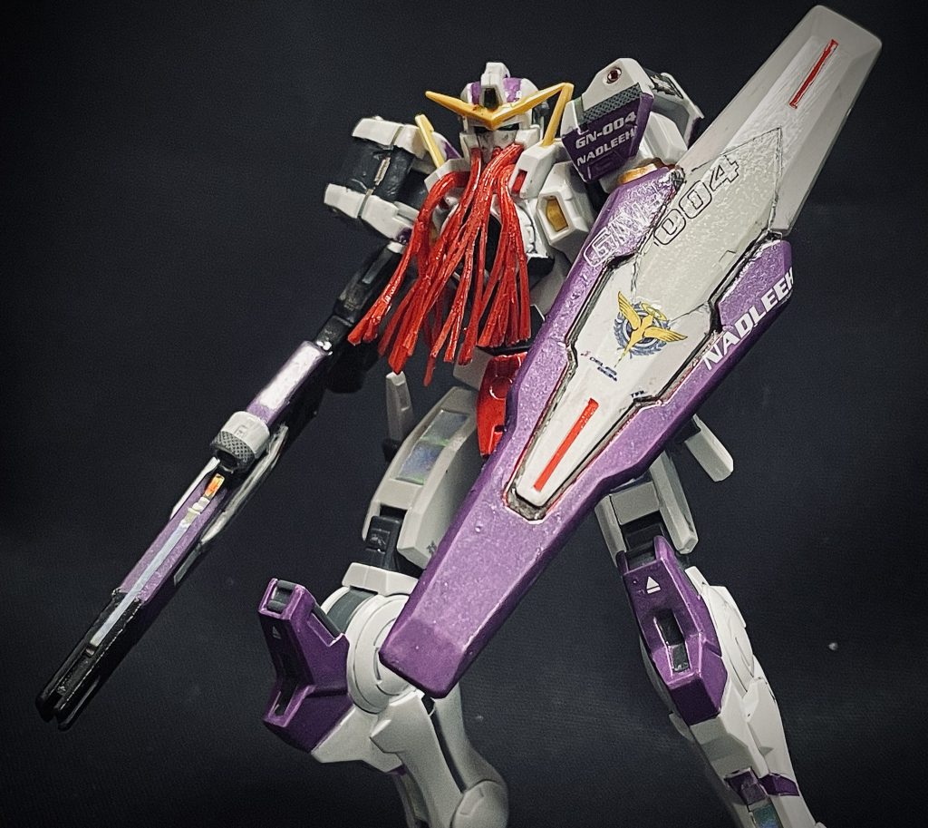 HGガンダムナドレは『白すぎる』と感じたため、機体カラーはHGガンダムヴァーチェ同様にティエリアのパイロットスーツカラーをイメージした「ステラパープル」に一部変更にしました。頭部と胸部がら出ているケーブルはラインに沿ってカットし動きが出るようにしました。軟質素材でしたのでカット後に動きをつけて接着、その後に赤で塗装しました。肩にはビーズを埋め込み金属感を出し、他機体よりもボディにケーブル箇所が多く、オーロラシールが大活躍でした。