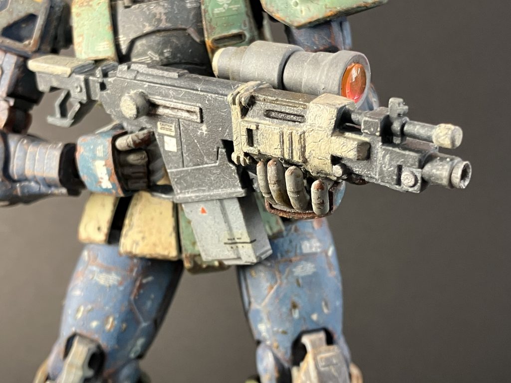 キットの大型対艦ライフルを砲身ゼロに切り詰めました。効かないマシンガン持つより、対MS戦に使うんだという強い意思表示です。何か新しい見慣れない兵器を持っているぞコイツ、でもどうせ大した事はないだろ、、、そう見えれば狙い通りにございます。彼は相手の油断さえも武器にします。正月にお会いした祖父祖母の様にやや腰もカシヅキつつも、マシンガンとはひと味違う大口径高速徹甲弾を近距離からお見舞い差し上げます。