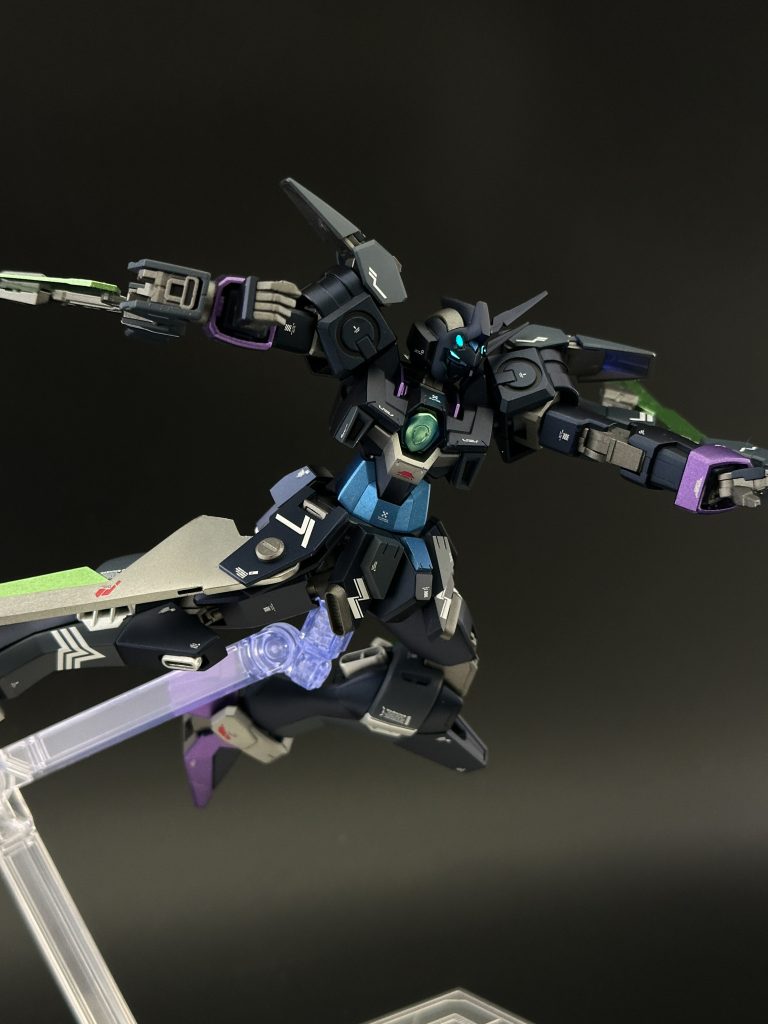 肩アーマーは小型かつ貧弱に見えないものを探して結局アルティメスのものに、キャノンの接続部は新たにボールジョイントを儲けてMGクアンタのサイドアーマーを取り付けました。この辺りからAGE-2の別ウェアという考え方を捨ててヒール機っぽくしよう、AGE-2なのだから対クジョウ・キョウヤという設定でカラーリングも意識しようというコンセプトが固まりました。結果背部のウイングは撤去し大型バーニアを増設、頭部も左側にアンテナ2本を寄せたアシンメトリーにしました。また今回1番手を加えたのはスカート周りです。インジャの足を導入するにあたってフロントとリアは形状変更し、サイドは姿勢制御用スタビライザー兼武器としてファトゥムの翼を採用し、邪魔にならないよう元の可動を活かして避けられるように調整しました。あとは胸の穴が気になったのでギラーガの胸ビームを埋め込んでます。