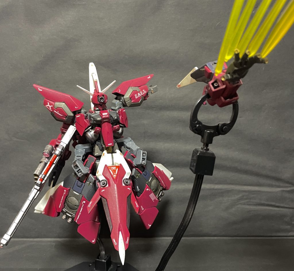 追加武装設定右手はイージスMSモードも考慮しライフルを握る必要のある手首自体は変更せず手甲部分に大型インコムビットを設置 (3本のインコムビットの指先部分はネオ・ジオング同様有線で射出可能設定)左手はシールドが直接腕固定タイプなのでフリーとなる手首ごと直結5連ビーム砲付き無線ドラグーンとしたさらにシールド前面の丸一モールドだった部分を拡散ビーム砲に付け替えたことで合体時には「ジオングらしい」腰部粒子砲として機能頭の額部にもジオングの口部粒子砲要素を付加  (当初は口に付けたところブサイクになったので)