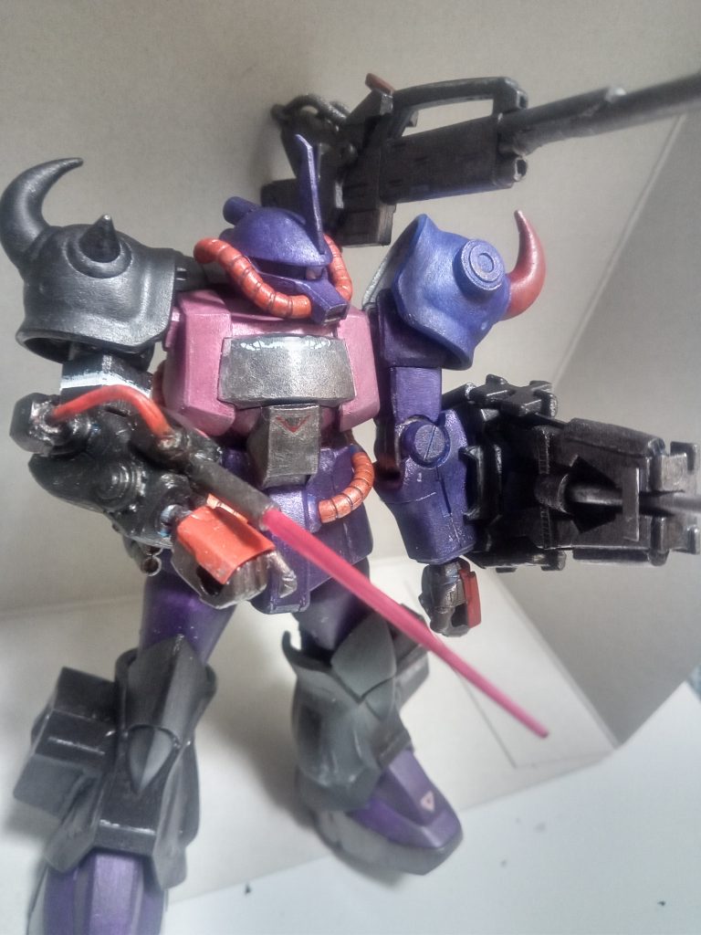 今回腕は敢えて左右で色を変えて塗ってみました。自分の中の脳内設定で、パイロットが若者であることからちょっとカッコつけた色にしたいだろうと考えてやってみた次第です(笑)今回の改修のコンセプトは、旧時代の型落ちMSであるグフにハイパワーのロングレンジビーム砲を取り付けて、遠距離から一気に敵機を破壊する一撃離脱型を想定しました。以下自分なりの脳内設定です。本機はグフを近代のMS戦に対応出来るように改修した機体である。無理やり取り付けたエネルギーパックのおかげである程度のビーム兵器は扱えるが無理やりの改修のせいでエネルギー効率は悪く、複数回のビーム兵器の使用はできなかった。また、近距離用の武装に乏しく距離を詰められると成すすべが無かったため奥の手としてのパイルバンカー、右腕に取り付けられた選択式小型ビーム・サーベルが採用されている。本機はカラバに所属する元ジオン派の小隊が使用していたと言われているが詳細は不明。一説にはジオン軍のエースパイロットであったランバ・ラルに関係した人物が乗っていたとも噂されている。こんな感じをイメージして自分なりにやりたいことをやってみました。