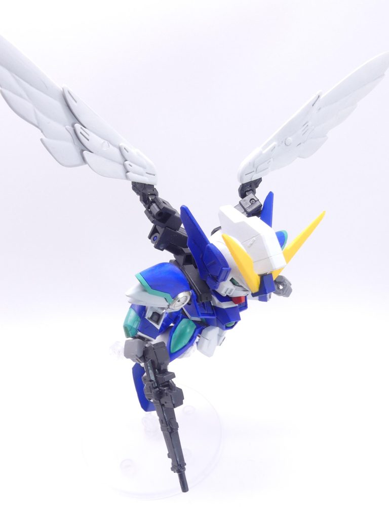 EX4「翼のリグレット」～シャクジイ・ゲンゾウが調査した、電書「エバーブック」の演者のレポートから抜粋～○月○日。SD仲間の間で噂されていた、「エバーブック」なる新作アプリのページに行き着いた。なんでも…ここでは、「ガンプラバトル」ができるらしい。早速ガンプラをスマホの画面の上に置いてスキャンし、ログインしてみた。…本当だ、凄い！私、確かにSDガンダムになって…空を飛んでいる…！○月×日。今日もバトルは勝利。現地の原生生物らしい「ミスク」は敵ではない。GP…ガンプラパワー、295…もっともっと高い人もいるにはいるらしい。ただし、アプリの注意書きにはこうある。「本アプリはβテスト中です。本アプリで得た情報は決して他のネット掲示板・SNSおよび近親者であっても口外しないこと」「また、敗北時、つまりあなたが「エバーランド」で破壊された場合、現実世界のガンプラ、およびログイン端末も同様の処理となります」…かなり脅し感が強い文言ではあった。ネットで調べても曖昧な情報しか流れてこないのはそのせいか。今だとネタばれ禁止、どこもやってるものね。とにかく、今も私はWセラフィムで空を飛んでいる。自分が作ったガンプラになって、風を感じている…