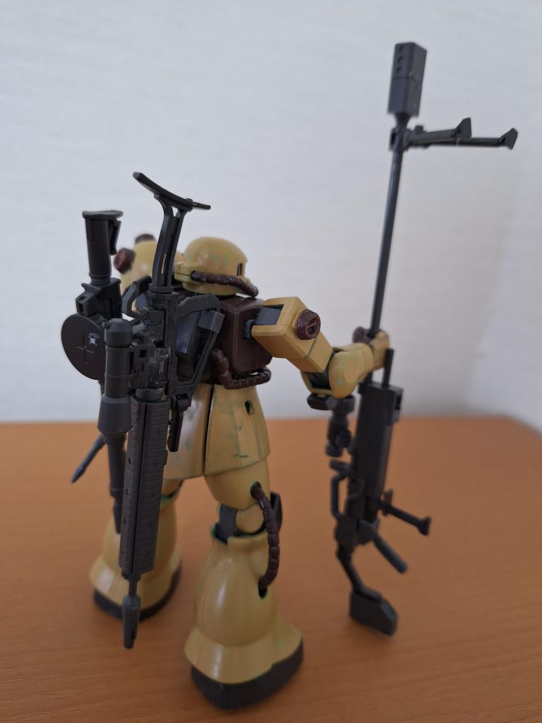 狙撃後も、背部に背負う、いずれもワンオフの大口径マシンガンとザクマシンガン後期型ロングバレル強化型で中～遠距離支援を継続するモビルスーツの設定です。