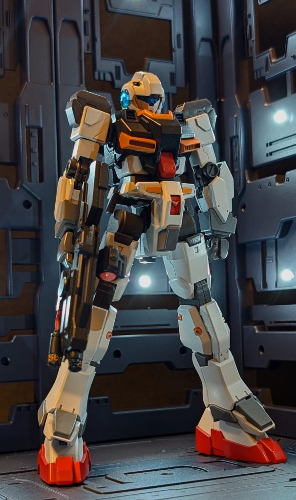 ~83番倉庫内~出っ歯「あそこの奥にあるのがジーラインですぁ!」出っ歯が指さした方向に目を向けると1体のひょろっとしたGM系の機体が目に入る。ミルク「…おい、出っ歯。てめぇ…」出っ歯の胸ぐらに掴みかかるミルク。ミルク「人の話聞いてなかったのか、てめぇ~!!こんなヒョロガリに何が守れるってんだ、あぁ!?」出っ歯「ちょちょ、ちょっと落ち着いてくだせぇ、ミルクの旦那!こ、このジーラインはアーマーを換装するタイプの機体なんでやんすよ!!」ミルク「な、なに!?換装だと!」出っ歯「そ、そうでやんす。アーマーを着せ替えて様々な状況に対応できる機体なんですぁ…。ハァハァ」ミルク「な、なんだよ、そういうことか。早とちりして悪かったな。すまん、許せ。」出っ歯「わ、わかってもらえたなら良かった…。とりあえずこの端末を見てくだせぇ。」タブレットを渡す出っ歯。出っ歯「ジーラインには4種類のアーマーがあって、今あっしのところで扱ってるのはこのスタンダードアーマーだけでやんす。」出っ歯「このスタンダードアーマーでもセカンド・ロットシリーズの最新技術で制作してるんで、アーマー込みの性能でやんすが、ネオ・ジオンの現用機にも引けをとりませんぜ。」出っ歯「つまりこいつぁジムの皮を被ったガンダムですぜ、旦那ぁ。ニヤリ」出っ歯「ご要望があれば他のアーマーもうちで製造できますが、部品調達に時間がかかるかもしれやせん。」ミルク「なるほどな。わっしの希望としてはこの”フルカスタム”が1番理想に近いが…」出っ歯「うーむ…フルカスタムだと最低2ヶ月は掛かってしまいますなぁ」ミルク「2ヶ月!?それじゃダメだ、間に合わん。」出っ歯「いやいや、旦那!スタンダードアーマーでも火力的には十分だと思いますがねぇ。スタンダードアーマーなら今日にでも持って帰れますぜ?」ミルク「…いいや、ダメだ!こんなんじゃ全然火力が足りん。」出っ歯(…ど、どんな機体を作ろうとしてんだこの旦那は…)ミルク「…おい。見たところ素体のジーラインには全身にハードポイントみたいな物があるな?」出っ歯「えぇ。そのハードポイントに対応できる装備ならスタンダードアーマーじゃなくても装備は可能ですぁ。」ミルク「…決めたぞ、出っ歯。わっしは自前でわっし専用のアーマーを拵えることにした…。」出っ歯「えぇ!?本気なんでやんすか?そんなんじゃアンタいくら金が掛かるか分かったもんじゃありませんぜ!?」ミルク「金のことなら大丈夫だ、このクレジット端末で連邦軍宛にツケといてくれ!」出っ歯(こ、これは…連邦軍の高官専用クレジット端末!!…ヤ、ヤバいぜ、この旦那はぁ。金の匂いがプンプンしやがる…!!)出っ歯「…へ、へへへ!わかりやした、旦那!あっしの負けでやんす。最後までお付き合いさせて頂きますよ、あっしのコネもツテも最大限にご活用してくださいませぇ!」こうして闇市の出っ歯の武器商人のコネとツテを最大限に使い自分専用アーマーを作ることに成功したミルク少尉。果たして他の小隊員の機体も無事に用意することができるのか!?次回に続く!!とりあえず今回は戦闘描写まで書くと話が長すぎるので、ミルク小隊の成り立ちとメンバー紹介、ジーライン・サラトガアーマー完成までのストーリーとさせて頂きます🙇♀️実は他の小隊員のMSも作る予定なので廃棄コロニー突入編は小隊員の機体を作ってからにしようと思ってます!