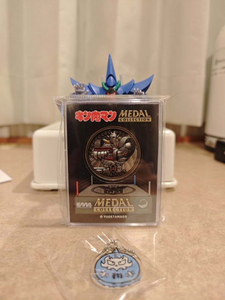 グッズもウォーズマン買おうた思ったのですが売り切れだったので代わりに将軍様のメダル買って来ました、これはこれでカッコいいのだ。ランダム販売のアクリルチャーム付きの肉みくじなるものもウォーズ、将軍様、アタル兄さんと好きな超人多かったので買ったのですがなんでよりにもよってマリポーサやねん…。