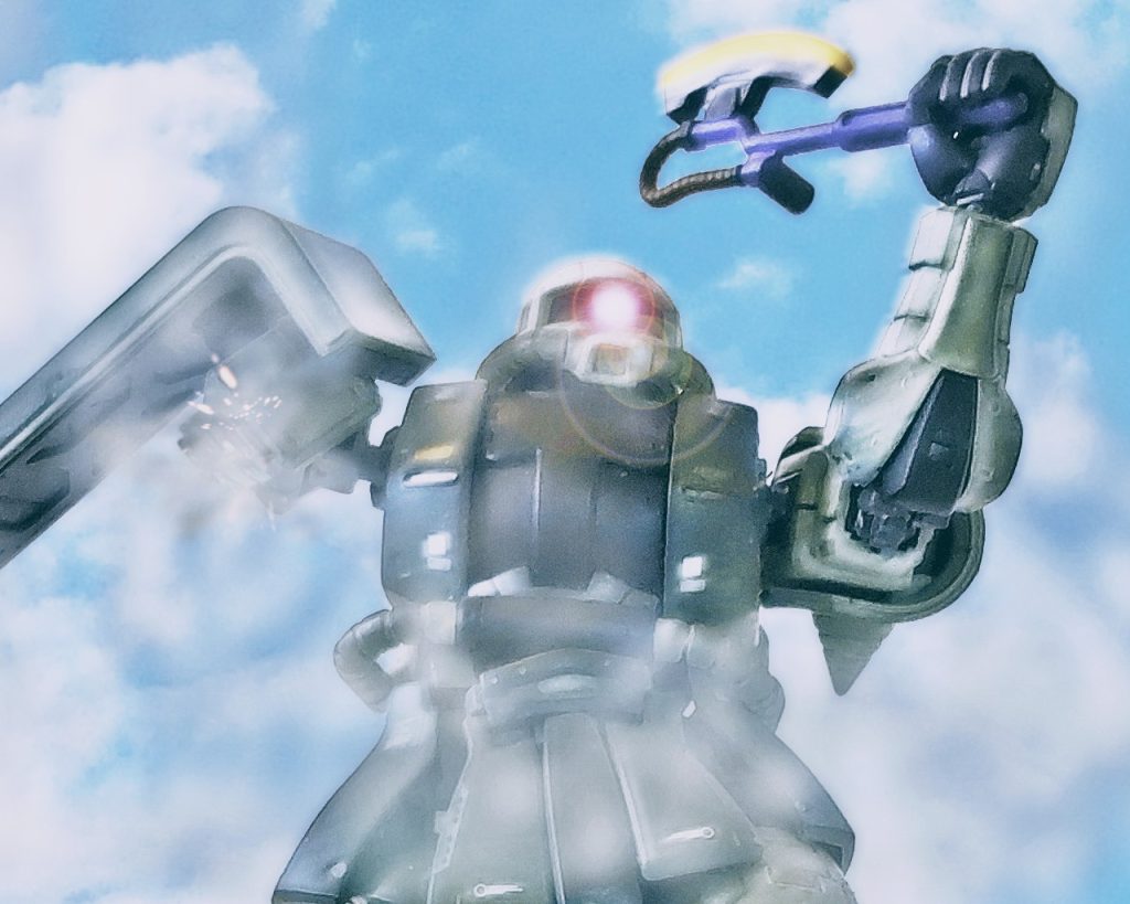 「俺はっ…、俺は宇宙に帰るんだっ…、生きて家族とっ…!!」片腕を失ったリンドヴルム隊のザクIIはヒートホークを振り上げると、覚束ない足取りでルースのジムコマンドに接近戦を試みる。「…聞こえるかっ!?ザクのパイロット!投降しろ!」ルース・カッセル中尉はハイパーバズーカの照準をザクIIに合わせたまま、パイロットへ投降を呼びかけた。しかしザクIIの応答はなく、接近を止める様子がない。「…チッ、あんな状態で正気か!?」ルースはザクの鬼気迫る姿に唾を呑む。ザクIIは取り憑かれた様に進むと最後の力を振り絞りブースターを吹かす。(……仕方ないっ)ジムコマンドがハイパーバズーカのトリガーを引くと、弾は一直線にザクIIへ飛んでいく。ブースターの加速により前進していたザクIIは、そのまま避けきれず胴体に直撃を受け倒れた。