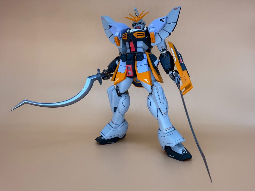改造点として、マッシブに見えるよう腰回りを少し太くしています。あと少し足を延長。頭部はスジボリを掘り込み、ほおあてを少し削っています。後は丁寧な基本工作を心がけました。カラーリングは、エアブラシによる塗装で、イエロー(ビビットオレンジ)がアクセントとして映えるよう、本体の白はグレー寄りにしています。