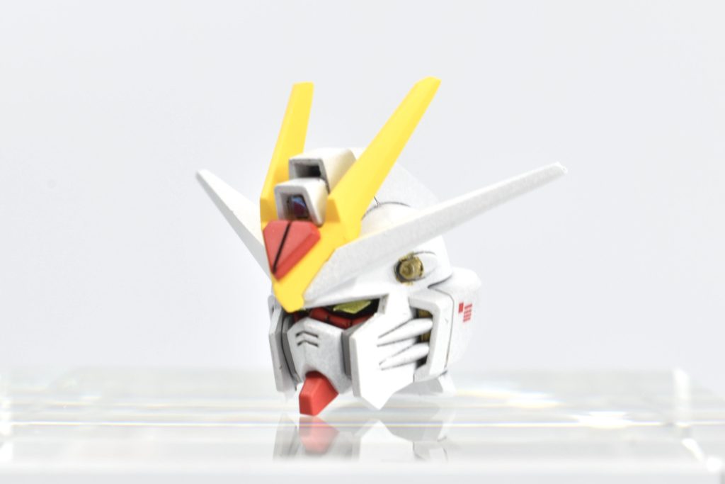 まずは頭部。アンテナはシャープ化。合わせ目も分割ラインを変更し、一部消しました。ツインアイは設定通りのイエローに変更。バルカンは4アーティストマーカーのゴールドで色分け。センサー部分は、付属のシールにオーロラシールを重ね貼り。