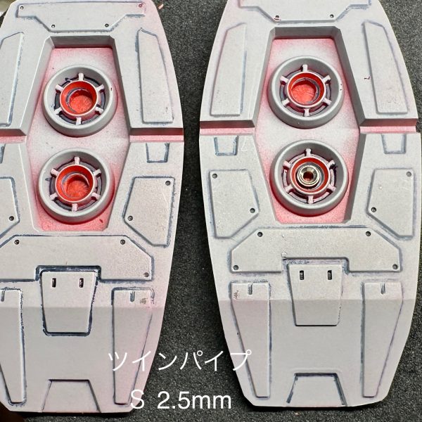 MGガンダムVer.Kaジャンク復活の続き。前回までで全身のパネルラインの追加が終わったのでここからはさらにディティールを精査していきます。とりあえず今回はメタルパーツの取り付け加工。すでに加工済みのところも含め改めてサイズや取り付け深さなども確認しつつ加工していきます。サイズや種類の備忘も兼ねて写真を撮って残していきます。まずはバーニア系から。このキットにはいくつかバーニアやアポジモーターのディティールがあるのでそこにハイキューパーツのツインパイプの取り付け加工していきます。今回ツインパイプはSサイズの1.5mm、2mm、2.5mmを用意しました。結局1.5mmは使わなそうでしたが取り付け部位の大きさに合わせてsサイズを選定、ピンバイスで掘り込んだ後にスピンブレードで底面を平らに整えていきました。ツインパイプの埋め込みは塗装の厚さを考えると+0.1mmほどの穴を開けたかったのですが手持ちのスピンブレードでは適合サイズがなく、今後のことを考えると使いそうな大きさ単品だけでも買っておいて損はないかなとは思いつつとりあえずはパーツジャストサイズで掘り込みました。フロントスカートにはマイナスモールドとスチールボールの取り付け加工。こちらもハイキューパーツのものを使用。そして頭部バルカンには同じくハイキューパーツのEZガンマズルショートを使用。ショートの1.5mmを買いましたがもっと太くてもよかったかも。取り付けの基部も削り込んでもっと奥まで差し込めたらいいかなと思いつつとりあえずはって感じです。ここはもう少し調べて追加加工を行うかもしれません。あとは適宜全身にマイナスモールドや0.7mmのスチールボールドをリベットのように埋め込もうかなと思ってます。それではまた。（3枚目）