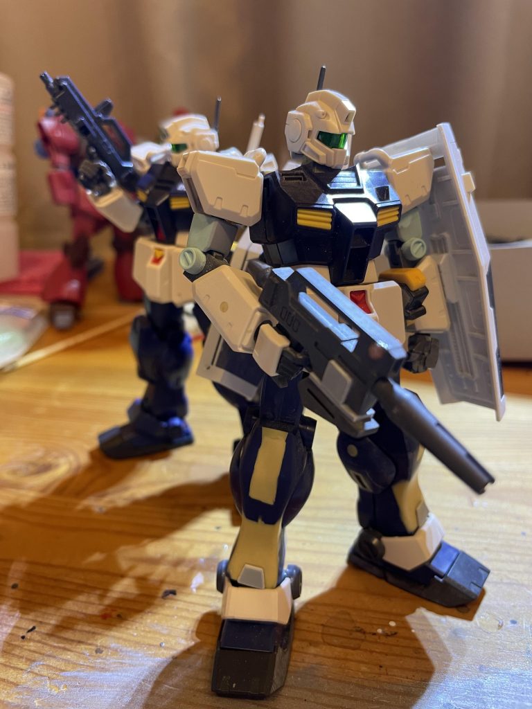 ⚠️おっと後ろの機体は見なかったことにしてくれ HGUCジム改はとにかくプロポーションが最悪で当時のバンダイの新卒君が考えたのかは知らんが近年稀に見るゴリラ体型なのが非常に残念だ、設計した彼は是非ビーストウォーズのコンボイでも作ってくれ このジム改は腕が長く足が短い、クラスいたらいじりの標的になるのは言うまでもない🤦実際問題ネットでは旧キットサイサリスとHGストフリぐらいイジられているからなぁ そんなことで今回彼は野ブタプロデュースしていく。 まず頭から。何もいじってない 胴体はジム・クゥエルのセンサーを移植したのと片方の肩をくり抜いてダクトをぶち込んだ。設定画を見るとなかなかイカしてるデザインをしているが俺ちゃんにはここまでできないのでシンプルな造形に仕上がった。 腕はとにかく長い！しつこいがほんとに長い！ジム改を制作した人は何も違和感を感じないのか？と問いかけたくなるぐらい長い！ そんなことでジムIIの腕関節を移植。形を整えて腕の違和感を無くすことに成功。みんなも是非ジム改を制作する時は俺ちゃんのを真似してくれ。 腕の丸い奴と二の腕はHGUCジムのを移植。丸は本来腕部分についているが切断し二の腕にくっつける。 股のスラスターみたいなのはコトブキヤのパーツを枠に入るように形を整えてからくっつける。両方の腰はジム・クゥエルから移植。そうすることにより予備のEパックをそのまま付けられる。 1番苦労したのは足全体🦵まずジム改のパーツはアンクルアーマーしかないのは言うまでもない。（なんならこれも使う予定はなかった）とにかく足が短いのでジム・クゥエルの足を全体移植。そうすることにより足の短さは少しは軽減されるが、ジム改高機動型の設定画に忠実なプロポーションは難しくなる。足を長くすることには成功したが全然スリムな体型にはなってない。だがAOZの機体は少しごついのが醍醐味。逆にこの体型こそ至高と考えることにした。 ふくらはぎにはスラスターが追加されるのでコトブキヤのダクトノズルを穴を開けてぶち込む。エポパテを使い隙間を埋めて完全硬化したら削り、僅かな隙間は瞬間接着剤で消すを繰り返し何とかフラットなふくらはぎを維持し、スラスターを再現出来たが、この形状は設定画とは違い、どちらかと言うとジムIIに似ている。まぁこの作業はちょいとむずなのでまぁいいとする。 足の形状もジム改に近づけるためエポパテを使い、形を整形しジム改に近づけた。ショックアブゾーバーはヘイズル系のEパックホルダーの黄色パーツを使いエポパテも交え整形しそのままくっつけた（本当はショックアブゾーバーの形に沿って穴を開けそのまま差し込めるようにしたかったが、やめてエポパテで封じた🤪） ビームライフルはジムIIのものを使用EパックはヘイズルからライフルとEパックの間はプラ板で作成。 シールドはブルーデスティニー3号機のシールドを使用。形状がジム改とは少し違うのでHGUCのラインナップで1番近い彼のシールドを拝借。（返さない）   