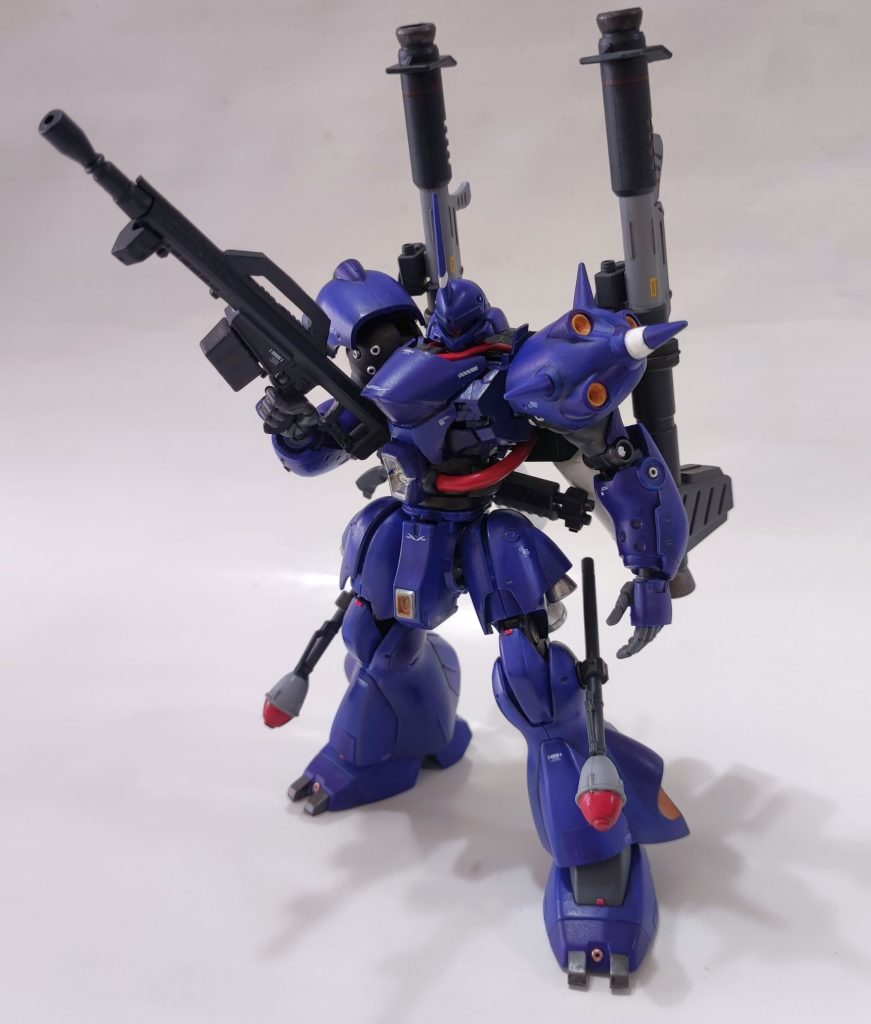 立ち姿。サザビーの胴を移植するにあたり、赤色ベースの”シャア専用” にするか悩みましたが、ケンプファーはやっぱ青しか勝たん、ということで青に。非常に分かりにくいですけど、青は二色塗り分けています。加えて、リアルタッチマーカーでの陰影を追加し、デカール＋艶消しスプレーでのコーティングです。メタルビーズは今回初適用。厳密に言うと、100均で買った「ガラスビーズのメタリックコーティング版」なのですが、思ったより良いです。大きさにばらつきがあるので選別作業があるものの、1個あたり数銭くらいの圧倒的コスパです。圧倒的な推進力を持つケンプファーをベースに、宇宙用に改修されたプラン。拡散メガ粒子砲を追加し、拠点への強襲能力を更に向上させた。ジェネレータ出力を補うため、大型のバックパックを装備し、推進剤の補填としてプロペラントタンクも追加…というコンセプトでの計画がなされたが、「10年早い」という上司の一言で計画は白紙に。デザインした設計者はその後、ネオジオン→アナハイムへと渡り、悲願の達成をしたとか…。という妄想で作成しました。