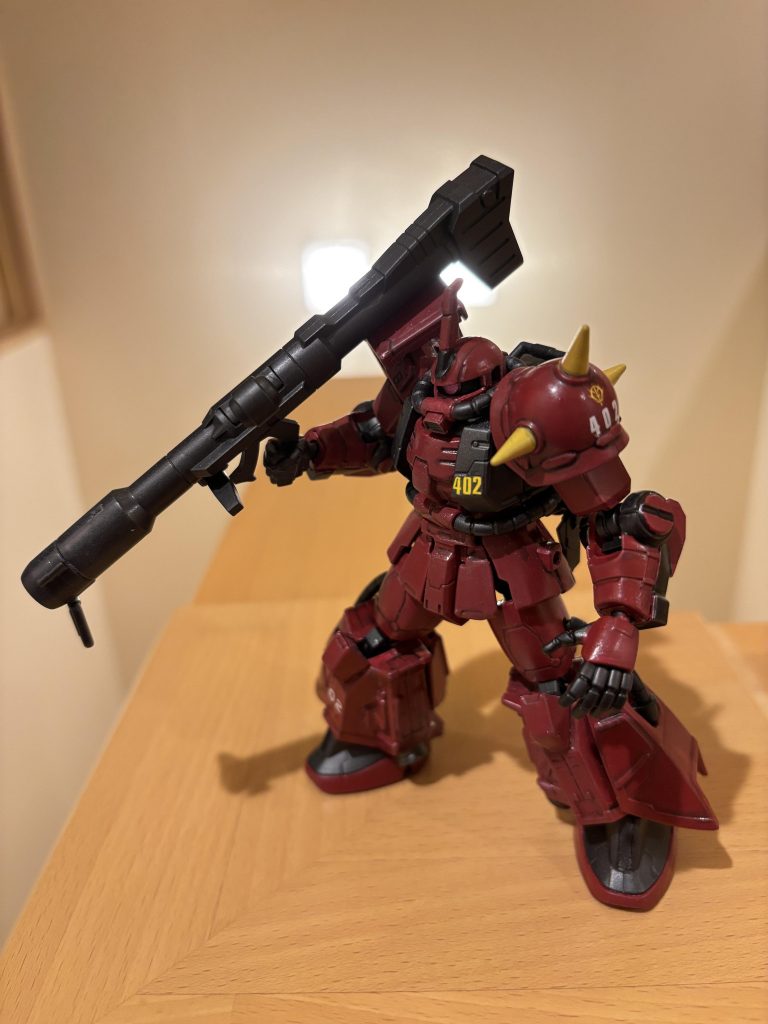 二機目はジョニー・ライデン専用高機動型ザクです。以前中古ホビーショップで購入していたものを、FA化してから塗装し直し。こちらもあずき色にしてみたのですが、なんだか色味が違う……暗めの色合いの方が好きではありますが、ジョニー・ライデンのイメージでは無い気がします。こちらはサーフェイサー（銀）の上に水性塗料です。水性だと、各機体カラー用に調整されている塗料も出ていて「ソードインパルスレッド」や「ダリルバルデレッド」なる塗料も持っていたのですが、どちらもオレンジというかピンクっぽくて、あずき色にしてしまいました。他の制作で使っていたダリルバルデレッドが、乾くとしっかりとした赤になっていたので、塗りはかなり後悔しています。最近出ていたリアルタイプザクから、フレームと二の腕・太もものパーツを頂戴して、FA化。旧GフレームとGフレームFAでは、フレームが一部と違うところがあるので、意外と大変でした。