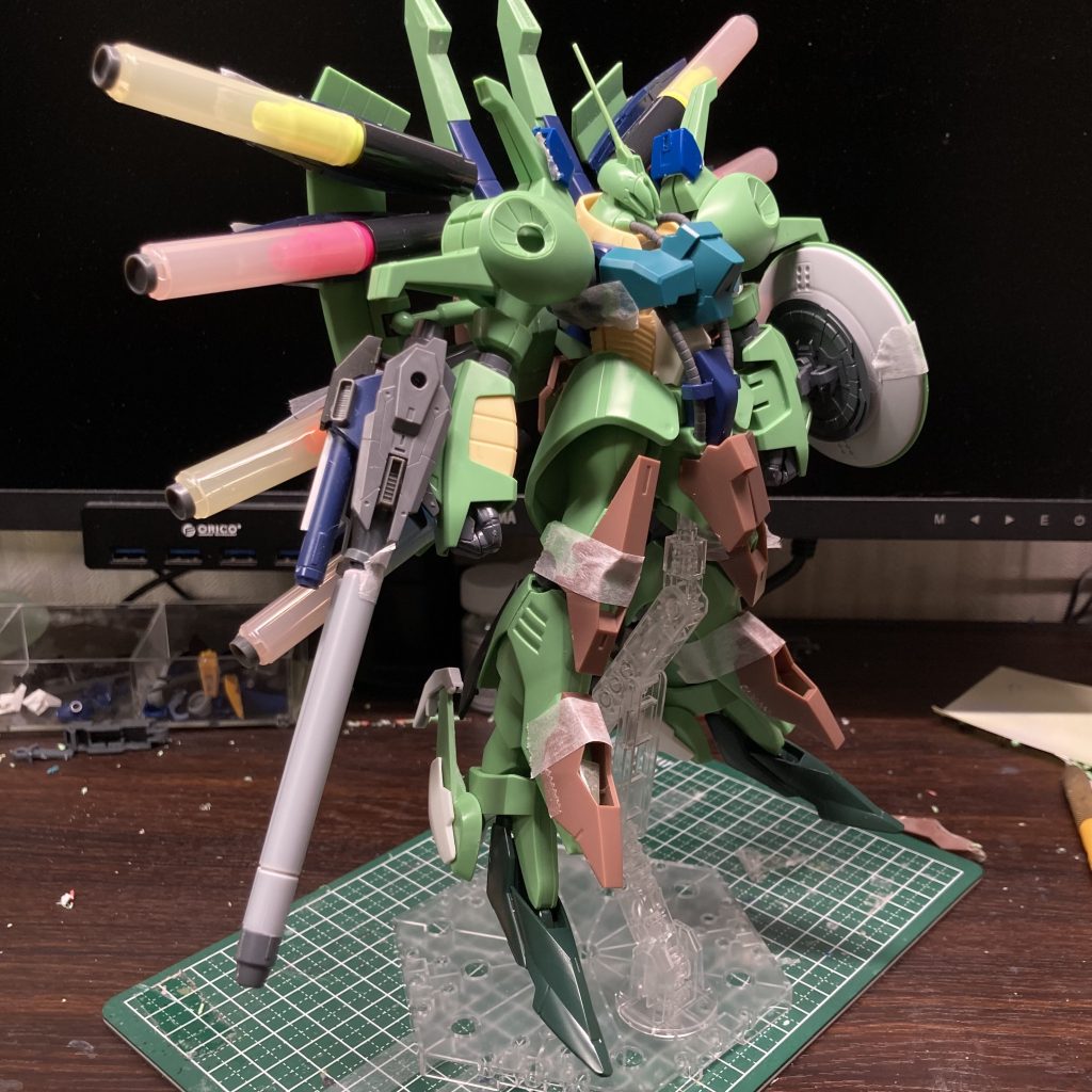 恥ずかしい途中写真・・・ パーツを仮止めして、全体のバランスをチェックしている段階です。ミサイルに蛍光ペンのパーツを使っているのでカラフルで綺麗です。下半身の茶色のパーツはルブリスソーンから。つま先はレギンレイズジュリアです。・・っていうか、机の上、きたないぞっ!