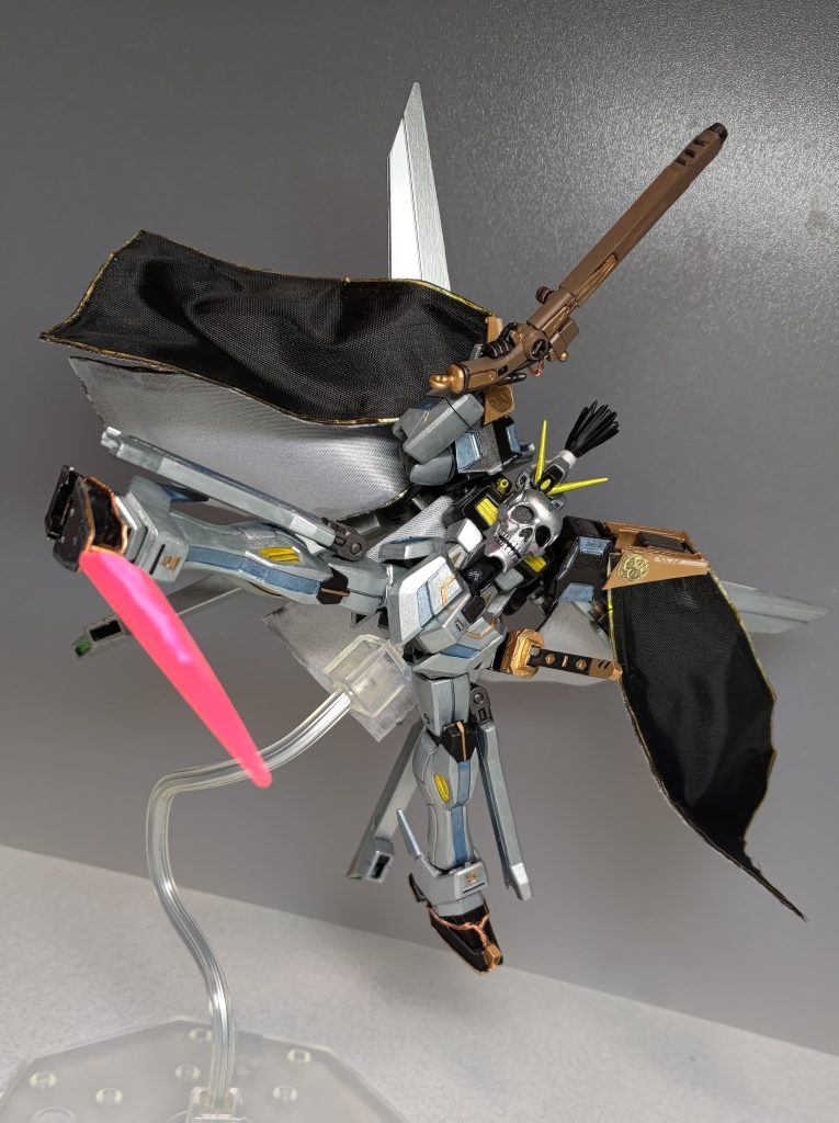 さらに、足裏から爪先へエネルギーチューブに模した撚り合わせ銅線を這わせ、爪先へプラ板を接着しました。こちらからもクロスボーンソードを展開可能です。アルケーガンダムみたいな装備ですね。この爪先ソード、銅線で草鞋の紐を表現できないかなぁという思い付きからの副産物なのですが、なにか活用できないかと考えたところ、背中のキャノンに目を付けました。