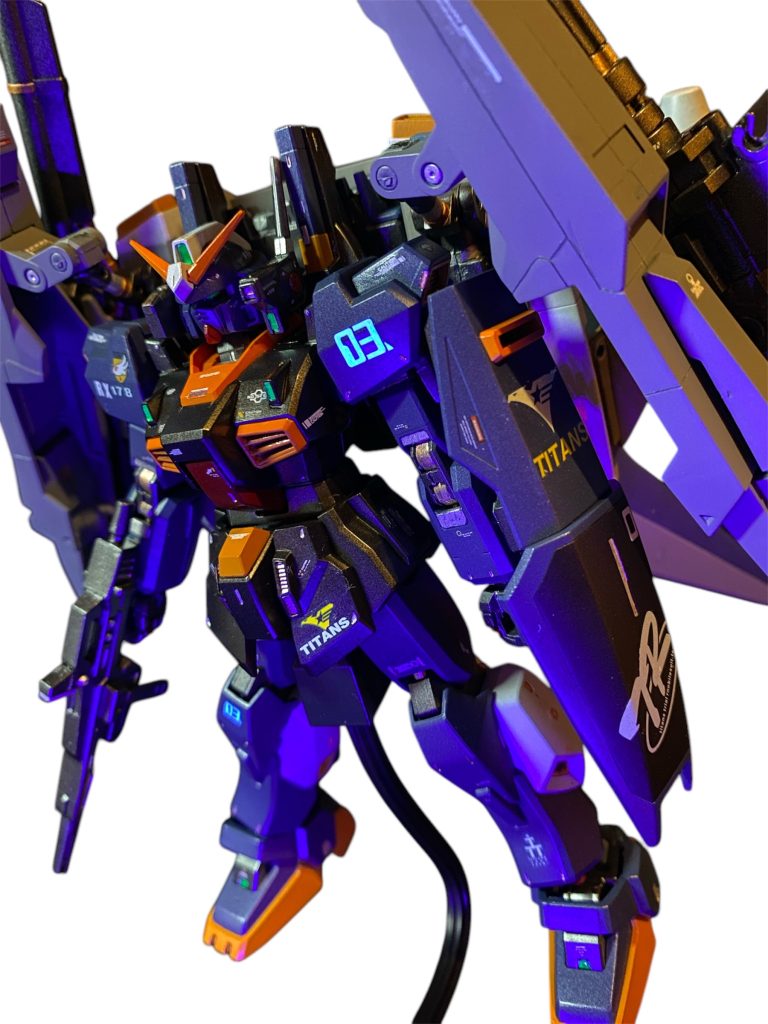 「アポリー中尉、リック・ディアスの調子はどうか？」「申し訳ありません、クワトロ大尉、、ずっとザクに乗っていた身からすると何ともこのコクピットは慣れませんで、、、自分の手足の様に操るには、1週間くらいは必要かもしれません。」「自分たちはマニュアル通りの訓練なんかやってないつもりだったんですが、こうも進化すると。。また“マニュアルはちゃんと読んだんですか！？”ってアストナージにドヤされそうだ。」「やむを得んか、、グリプスへの強行偵察はもうしばらく先送りにするしかないな。昔から“過信は自分の足元をすくう”と言うからな。」 UC0087年、ティターンズによる新たなるガンダム“マークⅡ”の開発は順調に進み完成した。出資していた対立組織エゥーゴも表立った行動を起こせずにいた為に、今後の情勢を見てどちらにも恩を売っておく必要に迫られたアナハイム社は、マークⅡ用の強化装備プランを売り込む事を決定する。それにはティターンズが初めて開発に成功したというムーバブルフレームの技術を自社でも手に入れたいという目論見もあった。これは謂わゆる“政治的取引”というものである。