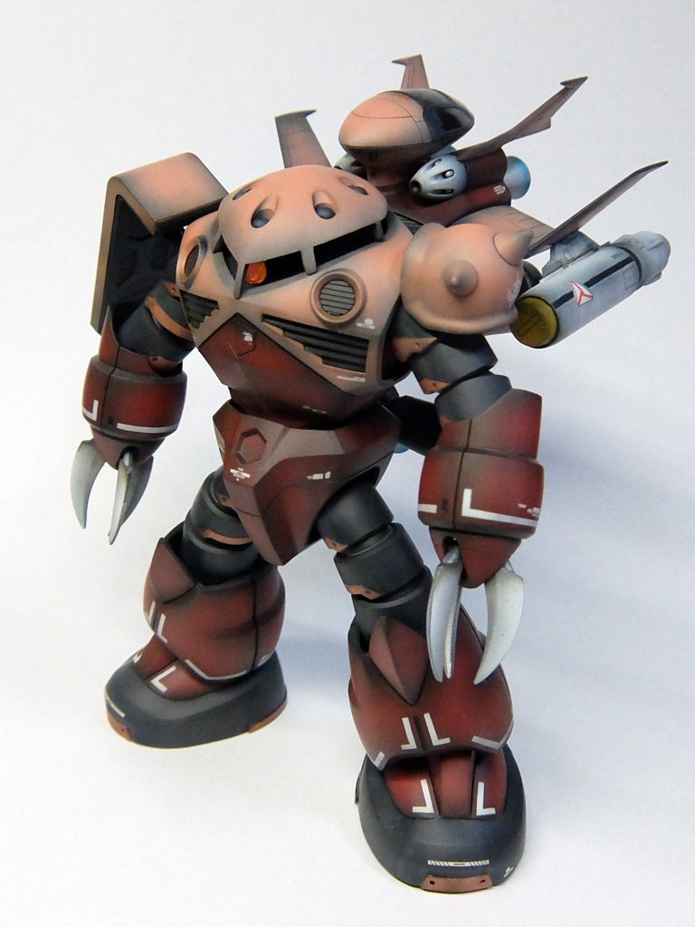 【今回のバックストーリー】 （長文でスンマセン・・・） ジャブロー攻略戦後のジオン軍メカニックの会話→また変なん造ってるやん！どぉしたん？ →こないだシャア大佐がな、休みの日にSEED何とかっちゅう映画見に行ったらしいわ。 　それにな、ハネのあるズゴック出てたんやって。 　ほんで、「私のズゴックにはなぜ翼がないのだね。」とか言い出しはってな。 →えっ！うちの軍に休みの日ってあるん！？ →食いつく所そこちゃうで。 　まぁ、上の人らはあるらしいで。 　大佐なんかわざわざマスクとってサングラスして飲みに行ってるんやて。 　「坊やだからさ」って言い出したら、酔いだしたなって注意せなあかんで。忘れなや。 →うん、覚えとくわ。 　でも、ズゴックて水陸両用やん。空飛ぶようにできてへんからハネなくて当たり前ちゃうん？ →やろ。そぉ言うたんやで。 　でもな、「翼があればバランサーがくるう事もなかっただろうに・・・」ってグチグチ言いよるねん。→あぁ、今バランサーがどぉのって大佐の中で流行ってるらしいな。 →ほんま、ずーっと言うてるで。 　自分やられただけやのに、わざわざコクピットのレコーダーに残るように「バランサーが狂ったのか」とか声まで出してんねんで。 →ねちっこ！ →でもな、ちょっと見て！　やっつけ仕事のわりに、ええもんできたんよ。 　背中のコアドップを切り離したら、水の中でも大丈夫やねん。 →コアドップって、ドップやん。コアでも何でもないやん。 　ほんで水から出て、次に飛ぶんどぉするん？ →水面でパイルダーオン！すんねん。 →ちゃうもん混ざっとるがな。 　そやけど、そんなんできるんかいな・・・ →できるて。 　「大丈夫」ってマチルダさんが教えてくれたから、たぶん大丈夫や。 →お前、大佐よりニュータイプちゃうか!? →ほんでな、ほんでな！ コアドップってすごいねんで！ 　やられたー！って非常の時、脱出ポッドとしても使えるねん！ →そんな非常時に外に出てドップのコクピットに移動して脱出、とかできるわけないやん。 →いや、大丈夫や。「大丈夫」ってマチルダさん言うてたもん。→そぉなん・・・よぉ出てくんな・・・ 　マチルダさん、うちの軍でもすっかり有名人やね。 　まぁ作ったお前が気に入ってるんやったら、それでええんちゃう？ 　あとは大佐が気にいるかどぉかや。 →それも大丈夫や。 　しょっちゅうザクザク言うてるから、サービスでザクのトゲトゲと盾つけといたし！ 　ザクのんやからだいぶ小さいけど。ちゅうか、ズゴックがゴツいねん。 　このままやとモビルスーツってどんどん大型化してきそうで、重いし場所とるしで・・・ →あっ！大佐来たで！ →ほー、これが新しい私のズゴックか。 　いいじゃないか。これでバランサーが狂う事もないだろう。 　ところで翼に反応弾が見当たらないようだが。 →了解致しました。反応弾も装備致します。 →そぉいうたら、こないだ映画館にマクロス見に行ったって誰か言うてたな・・・--- しかしメカニックの苦労もむなしく、シャアがホワイトベースを追って宇宙に上がったため、実戦に投入される事なく、格納庫で終戦の日を迎えたのが本機である。