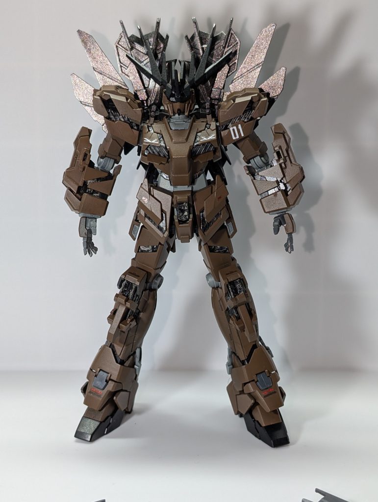 今回はHGバンシィ・ノルンのデストロイモードの色変えをしてみました。設定としては、ラプラス事変の前に稼働試験中に事故を起こして行方不明となった３号機フェネクスの代わりに、連邦軍からアナハイムへ発注していたフェネクスの予備パーツとバンシィの予備パーツで建造した２機目の連邦製RX-0、という感じです。型式の[SP]はスペアの意味です。機体名に付いている「ノマド」は、「群れを持たない雄ライオン」という意味で、獅子モチーフのバンシィと兄弟機であるというニュアンスです。(昨年末に作成した