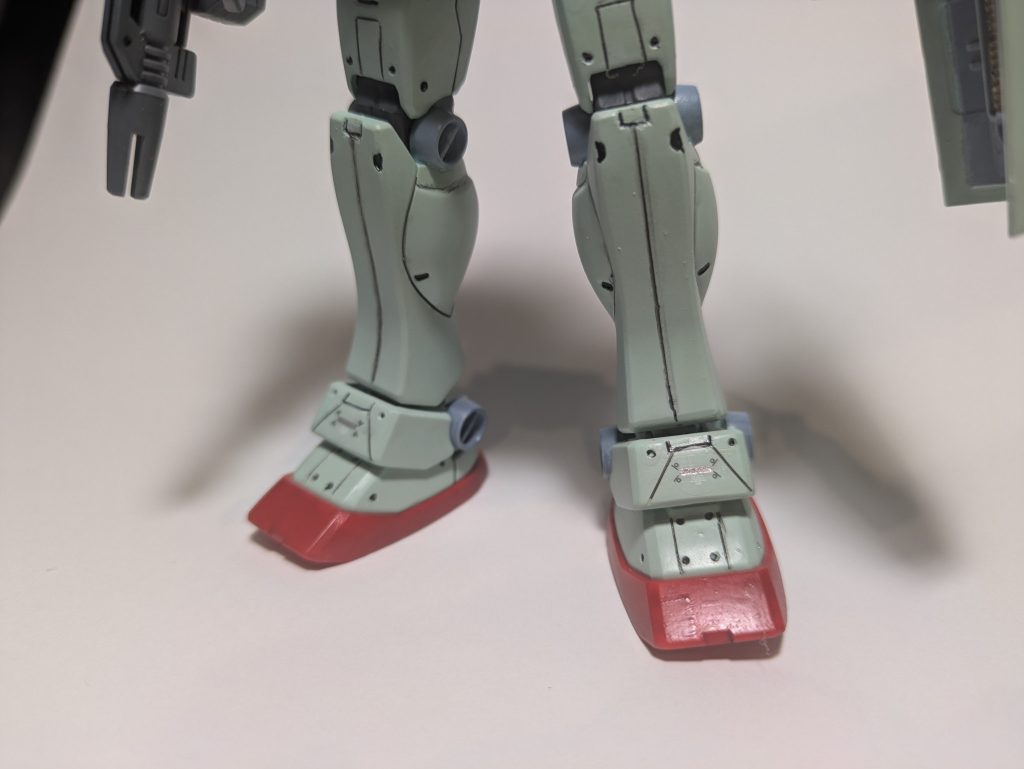 スネは段落ち的なやつにしようとしたら、なまら太くなったので、スミ入れを細くしてごまかし。あちこちにあるリベット(?)は、スピンモールド…なんて高級品は持ってないのでダイソーの細いピンバイスで貫かない程度に穴あけ。まあ、何箇所か貫いて裏からプラ版貼ってるんだけど