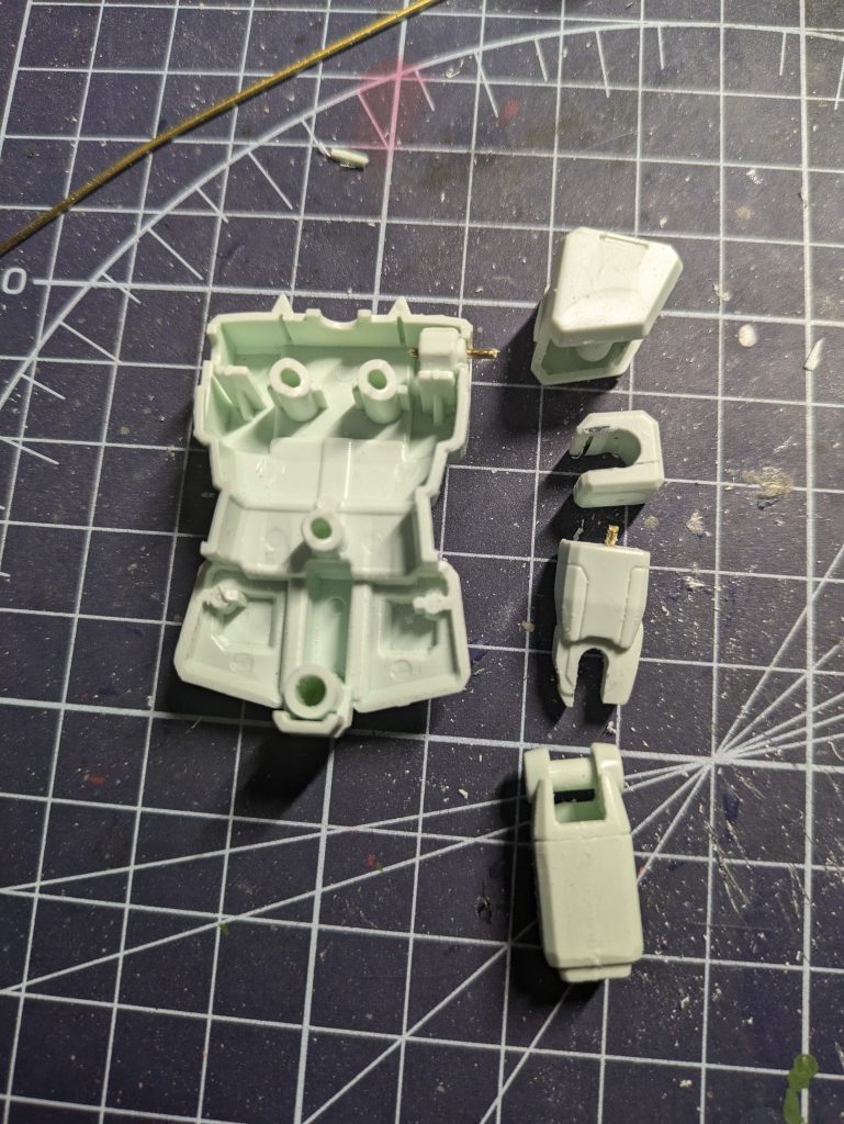 腕に関しても合わせ目消し等の処理がしやすいように分割。関節は見えないところをCジョイントのように切り欠くことで後ハメ加工ができます。これは固定モデルにする際は使いやすい方法なのでお勧めです。肩パーツは胴体との接着部に最初まっすぐ1mmの穴を空け切り離し。その後片側に真鍮線を差し込むことで諸々処理が終わったあと正規の位置に再接着しやすいようにしています。この処理は色んなところで行ってます。あと写真の枚数的に載せられてないのですが腕部を5mmほど短くしました。やり方は肩パーツと同じで切り離す前に1mmの穴を開けて切り離したあと再接着の際その穴に真鍮線を差し込むことでズレないようしました。どれくらい短くなったかは最後の比較写真でよくわかると思います。