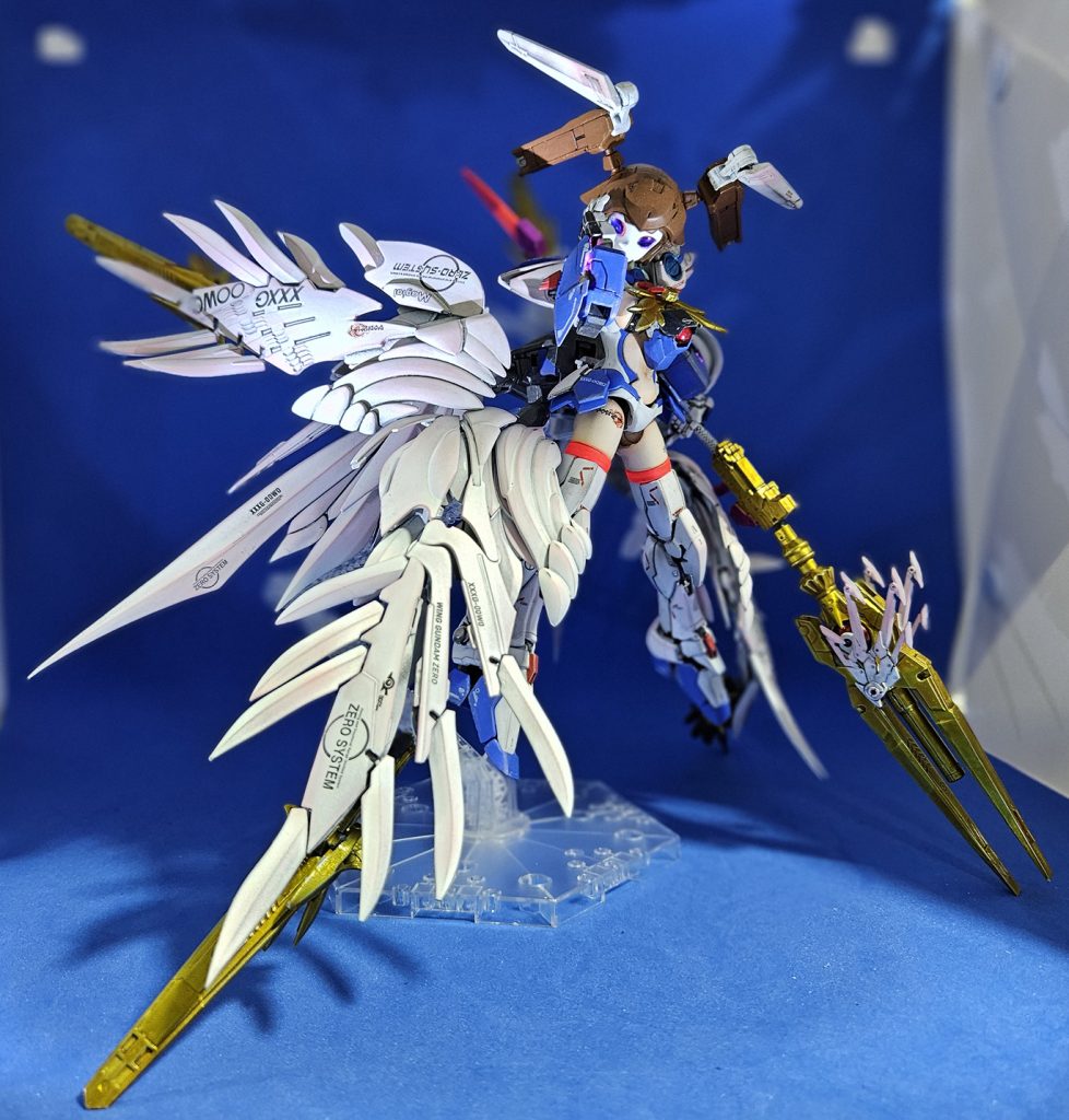 これも公式イラスト再現のつもりブラスタービット込みだと翼が足よりだいぶ長いので大体それが地についています横から展開モードを見ると背中に背負ってるのデカいなやっぱはい、以上で機動戦士リリカルなのはでした2年半ぶりのオリジナルです年始の頃にダイゼンガーを作ったんですがガンプラに限って言えばこれが2025年の初作品です私なりに愛を表現した作品です以下改造レシピ頭部：アチェルビータイプAをそのまま、ツインテールの部分にノーネイムライフルのフィンを追加して元ネタのリボンを見立て。胸部：30MSオプションボディパーツタイプG03を使用。真ん中に大穴を開けてRGウイングゼロEWのコクピットブロックを入れることで、「ゼロシステムをインストールした」設定に。腹部：30MSオプションボディパーツタイプA01を使用。下にゼロコクピットを保持するための磁石を仕込んでいましたが、磁石接続は磁気スイッチ付LEDと相性が極悪なため無駄な手間に。腰部：30MSオプションボディパーツタイプA01を使用、その上にイルシャナのスカートを追加。ウイングユニットはすべてスカートの3mm穴に接続しますのでここの負担が重いです。腕部：30MSの合わせ目ない方の肩を使用、そこからHGACウイングゼロスカイの腕を接続。前腕にはLEDを仕込んだRGウイングゼロEW腕パーツにを接着。肩アーマーはRGウイングゼロEWのやつを載せるだけ。手首は30MMのオプションパーツセット12を使用。脚部：合わせ目ない方の30MS太ももを使用、そこからRGウイングゼロEWの足を接続。アングルガードの外側に穴をあけて30MSエリエネ=エリエリカの翼パーツを追加して、元ネタのアクセルフィンを見立て。バックパック：RGウイングゼロEWのと、同人メーカー産の改造パーツを使用。ビットのノイエツバークも改造パーツ由来。武器：コトブキヤのアルナイルロッドをベースにアチェルビーとエリエネ=エリエリカのパーツを追加。タイトルロゴ：私が一晩で捏造した。大体こんな感じです今回は浪費なんて気にしないでこれまで集めてきたプラモを大量消費覚悟で作りましたそのせいで中破になったプラモがいくつかありますが、いつかまた違う形でよみがえるかもしれませんとは言え今は疲れたのでしばらくは素組で積みプラ崩しに専念するかな……？