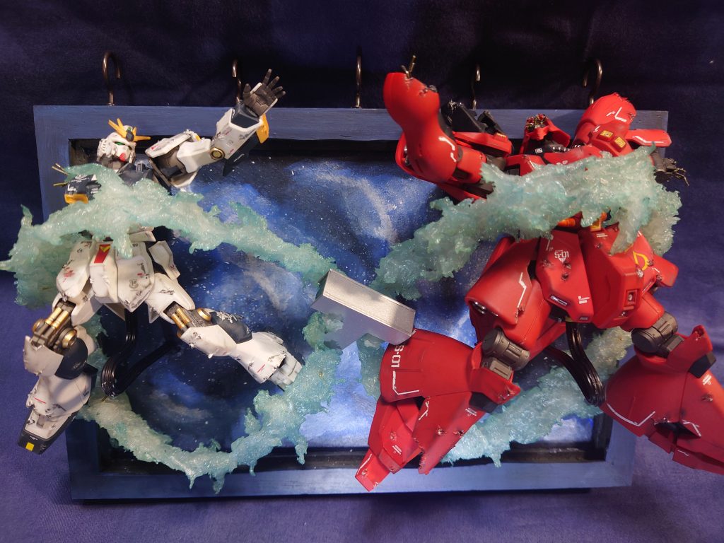 光の軌跡は透明粘土のすけるくんを使って成形し、クリアの塗料で仕上げ。土台は100均のポリエチレンフォームに木枠を接着して、塗装。背景の宇宙もアクリル絵の具で描いてます!