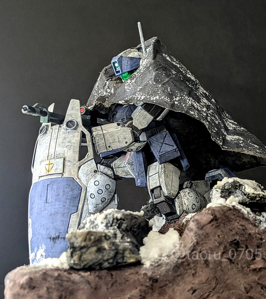 【設定】雪解けが始まった時期。山の尾根からの狙撃任務に就いたジム・スナイパーⅡジオラマ製作はずーっとやりたいと思っていたものの、「もう少しガンプラ作るのが上手くなったら・・」と先延ばしにしていました。先日展示会でお話しさせていただいた某世界大会のファイナリストになったモデラーさんから、「ガンプラもジオラマも、作らないと上手くなりませんよ」と言われて一念発起しました。「タオルに電流走る」って状態です。ジオラマをやりたいと思っていただけあってアイデアは貯めていたので、必要な知識と道具を準備してやり始めたら、なんとか形になりました。ジオラマベースの製作過程は後述します。