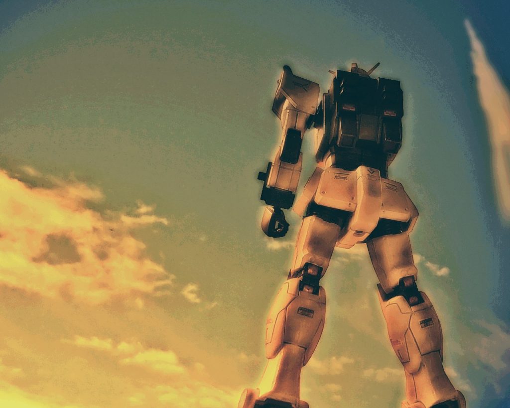 「…………」いつも強気なはずのライラの頭には追撃をする考えはなく、ガンダムはただそこに立ち尽くしていた。自分は運が良かった。今生きているのはただそれだけだ。「ライラ少尉、無事かっ!?」ルースからの無線だ。「……ああ、何とかね…」「すまない、時間を稼げなかった」「構わないよ、シャトルは死守できたんだから…」「痛てっ…、いったいヤツは何だったんだ!?」フォルドは腕を擦りつつ無線に混ざる。「分からん、まあここの調査チームが調べるだろう?」「手痛くやられたものさ…」「まったくだぜ、新型のジムがこんなだからな。けどG‐04なら、こんなじゃなかったけどな」「言っても仕方ないだろう、フォルド?」「へいへい、じゃあ後は頼んだぜライラ」フォルドはコクピットを開くと倒れたジムから出る。「…何がだい?」「俺達はジャブローに行くんだよ。このジムと後片付け、よろしくな!」フォルドはそう言うと無線を切り、走って待機しているミデアに向かった。「スマンな少尉、そういう事だ。報告書と始末書はジャブローから送ると司令には伝えておいてくれ。武運を祈る」ルースも続けてその場を後にする。「バカ共が…、さっさと行っちまいな!!後から追いかけてそのケツを引っ叩いてやるさね!」(……いい男なんだからそれまで死ぬんじゃないよ……、フォルド、ルース。…それにクリス、約束は守ったよ…)局地型ガンダムは夕陽に染まり、打ち上げられたシャトルの航跡を見上げた。