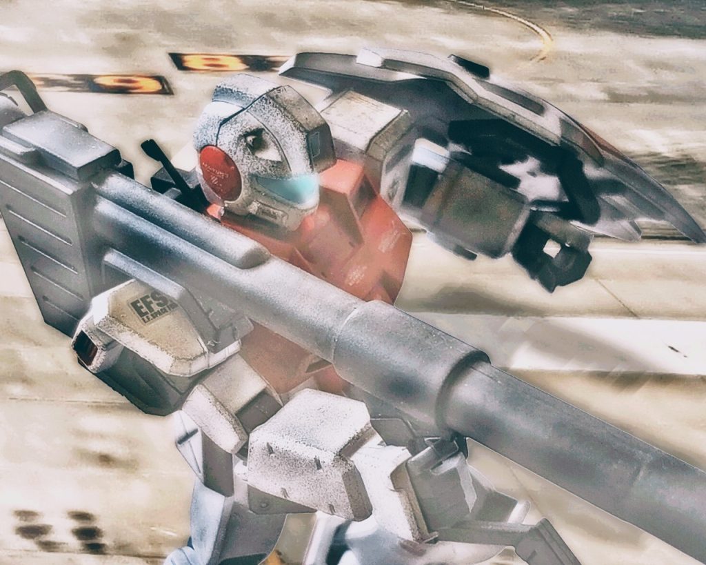 「何だあの赤い残像はっ…!?」ルースはハイパーバズーカでイフリート改を狙うが、当てるどころかロックオンすらままならない。そして、迂闊にもルースは狙いを定めるのに一瞬動きを止めてしまう。ニムバスはそれを見逃さなかった。イフリート改は大きく踏み込むとルースのジムコマンドに急接近し近接格闘を仕掛ける。「…チッ、遅いかっ!?」ジムコマンドは寸分の差でハイパーバズーカを投げ捨て後退すると、イフリート改はジムコマンド本体でなく、ハイパーバズーカを叩き斬る。斬られたバズーカは2機の間で爆発すると、目眩ましの様に視界を遮る。「…小賢しいなっ、連邦の!!」ニムバスはそれに怯む事なく前進するが、ルースのジムコマンドは視界から消えていた。「…そこかっ!!」イフリート改は咄嗟に振り向くと腕部グレネードランチャーを放つ。「…勘がいいヤツだっ!?」ルースは紙一重でそれを避けるとビームサーベルに持ち替え距離を取る。「…ルースっ!!」そこへフォルドが接近すると頭部バルカン砲で注意を逸らす。「フォルド、ヤツは普通じゃないっ!?無理に仕掛けるなっ!!」「んな事は分かってる、あの赤く光る粒子といい、さっきと違い過ぎる!!」2人は連携し、どちらかが一方的に狙われない様に動く。「さっきのライラのは聞いたなっ!?」「ああっ、狙撃するのに時間を稼げってな!」「恐らくビーム兵器によるロングレンジ射撃をするつもりだ!」「つまりそのチャージの時間を作ればいいんだろっ!?」「それだけじゃないっ、狙撃の為にヤツの動きも封じる必要があるっ!」「おいおい、無茶言うなよっ!?このジムじゃ付いていくのがやっとだぜ!?」「何とかするしかないっ、ライラの準備が完了したら2人同時にヤツに畳み掛ける!!」「出来るのかよっ!?」「やってみせろっ、フォルド!!」幸か不幸かイフリート改は2人に執拗に食いついている。どうやらライラの気配には気づいていない様子だ。だが2人のジムも限界に近い動きで静かに悲鳴を上げていた。