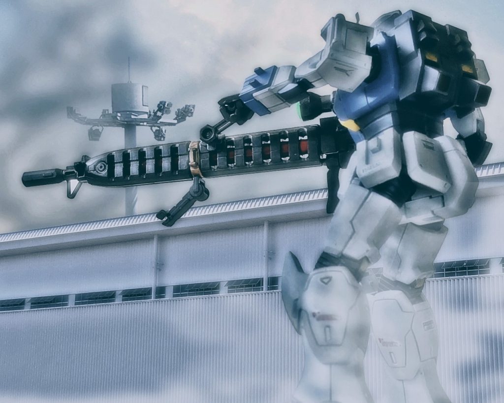 「ルースっ!!何が起きたっ?」ライラは叫ぶが応答はない。「…だったら」ロングレンジに対応したカメラを持つ試作大型ビームライフルのスコープ映像をガンダムのメインモニターに繋げた。方角と照準を合わせルース達のいる辺りを視認しようと試みる。するとそこに映ったのは、先刻とは違う動きを見せる敵機がいた。敵機の動きは全てを捉えきれず、直ぐ様カメラの画角から外れてしまう。「…なんだい、あの速さは……?」自分が相まみえた時とは違い、異様とも言える高機動と赤い残像が一瞬だが見えた。とても人間が操縦している動きには見えなかったが、紛れもない事実にライラも息を呑む。だが、空気に呑まれている場合ではないとルース達に通信する。「ルース、フォルド聞こえるかいっ!?返事はしなくていいからよく聞きなっ!!こっちはアンタ達から東へ1645ヤードにいる。そこから狙撃するから、あと2分もたせて可能な限り注意を引きつけなっ!!」そう言うとライラは一矢報いるのにビームライフルの充填を開始した。辺りは段々と赤く夕暮れに染まりだす。