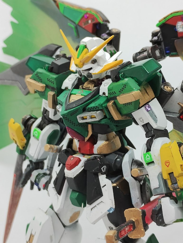 ・ネオジャパン特有の、鎧武者をモチーフにしたデザイン・シュバルツ=キョウジのコピーを通して得たガンダムシュピーゲル・ネオジャパンコロニーと融合して翼を広げた姿……このあたりをモチーフに盛り込み、ミキシングを進めました。スターバーニングガンダム&神バーニングガンダムをベースキットに、イメージに寄ってくれるパーツを盛り付けていきました。FC岐阜ユニフォームの意匠としては、模様を胴体のデカールで再現…したつもり。ちょっとゴールドの割合が多すぎたかもしれないです。ゴールド多いせいで、東京ヴェルディっぽい感じになっちゃいますね。