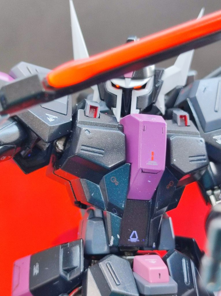 延長工作の他にしたこと。・アンテナとシールド先端、対艦刀の両端をプラ板でシャープ化・アマプラで映像を見て新規スジボリを追加・折角全塗装してるのに塗装レシピそのまんまなのもあれなので、肩のピンクと膝の黒パーツをダークピンクに変更・レッドチップ追加・目の部分はハイキューパーツのメタリックシールとラピーテープを切り出したものに蛍光レッドを筆塗り。
