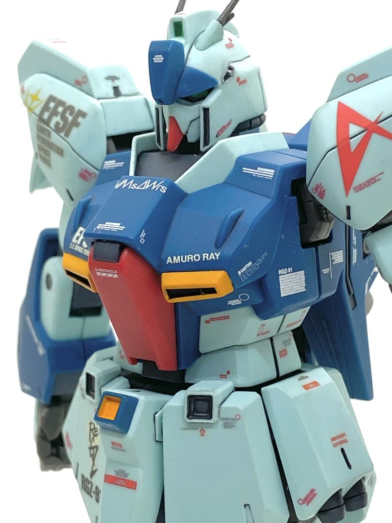 本体だけなら合わせ目あるのが頭と肩ぐらいで後はほぼ段落ち処理になっているので合わせ目消しは非常に楽です。リ・ガズィのデカールはMGやHGに逆襲のシャア用のがあるから豊富でガンガン使って、マーキングでリ・ガズィという機体をアピールしています(笑)。本来リ・ガズィはウェーブライダーに変形はしないですからVMsAWrs(ヴァモーズ、Variable Mobile-suit And Wave-rider system = モビルスーツとウェイブライダーに変形する機構)の機体に該当しないのですが・・・何かの資料にVMsAWrsのマーキングが入ったイラストを見た事があったのでZガンダムの関連機という事でVMsAWrsのマーキングガンガン入れました。MGリ・ガズィカスタムのデカールも多く使い、サイズ的には心配でしたが・・・案外違和感が無く、それなりにカッコ良くなったと思います。