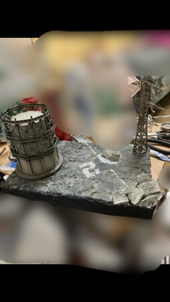 最後にウェザリングをしたジオコレのコンビナートと電波塔を設置してジオラマベースの完成です！アスファルトの色味の表現に使ったアストログラナイトは宇宙要塞や、隕石にも使えそうですね😆背景のモザイクは部屋が汚いので入れてます笑今回はMS同士が戦っている様子、アスファルト、ダメージの表現等、初めて行うチャレンジが沢山あり、とても苦労しましたがそれと同じくらい楽しかったです！！今後もガンプラを作っていく上で使えそうなテクニックも学べたのでそれも嬉しかったです！！拙い文章だったと思いますが最後までお読みいただきありがとうございましたm(_ _)m