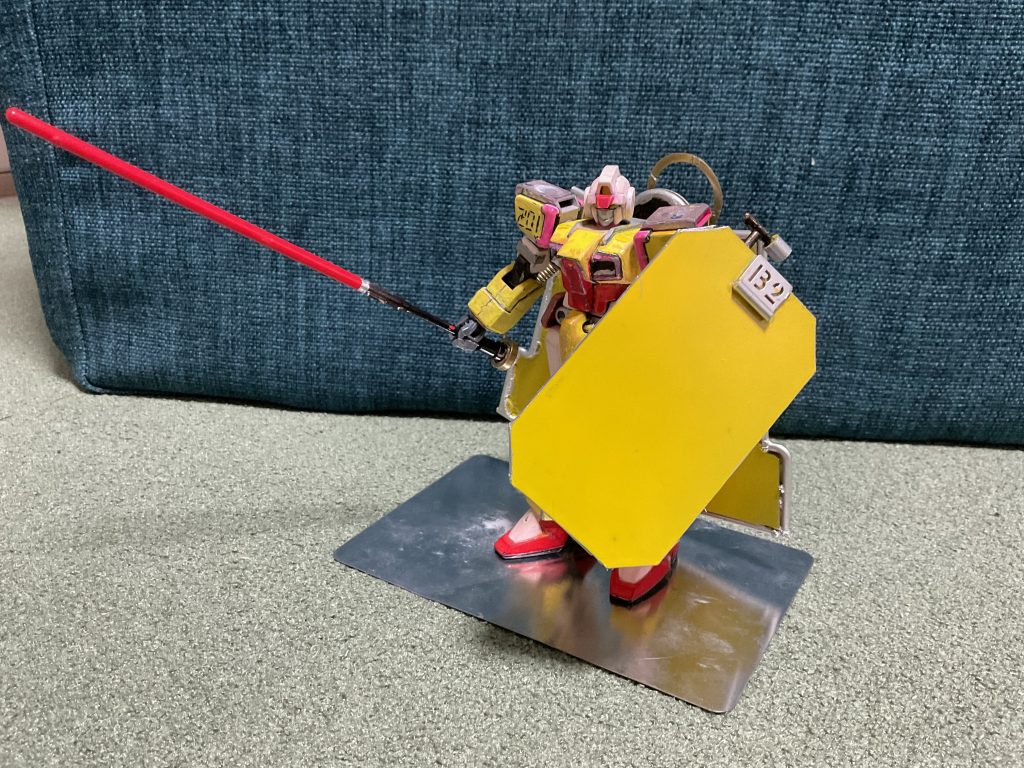 シールドシンプルで大きいが本来盾としてではなく作業用の足場や、高熱線防護としての運用が目的である。その為、戦闘用のシールドと比べると大きめではあるが軽量であり、格闘戦やマシンガン系のある程度の攻撃には対応しているが、強力な攻撃であればあまり期待はできない。