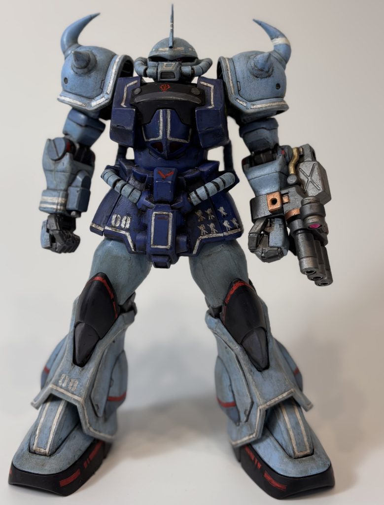 正面から。定番の目つき悪い加工と下半身を中心にボリュームアップを施しました。左右胸パーツ…上面と前面をプラ板でボリュームアップ。下面以外のバンダイエッジを消しました。上腕…ポリパテでボリュームアップ。筋肉なイメージで丸っぽく。頭部…モノアイスリットが細くなるよう削り込み。腰…フロントアーマーをプラ板で左右にボリュームアップ。太もも…縦割りにしプラ板でボリュームアップ。スネ…パーツ分割でふくらはぎ以外のパーツにプラ板を貼り付けてボリュームアップ。それに伴いふくらはぎパーツ接続部に同厚みのプラ板を貼りつけラインを揃えた。