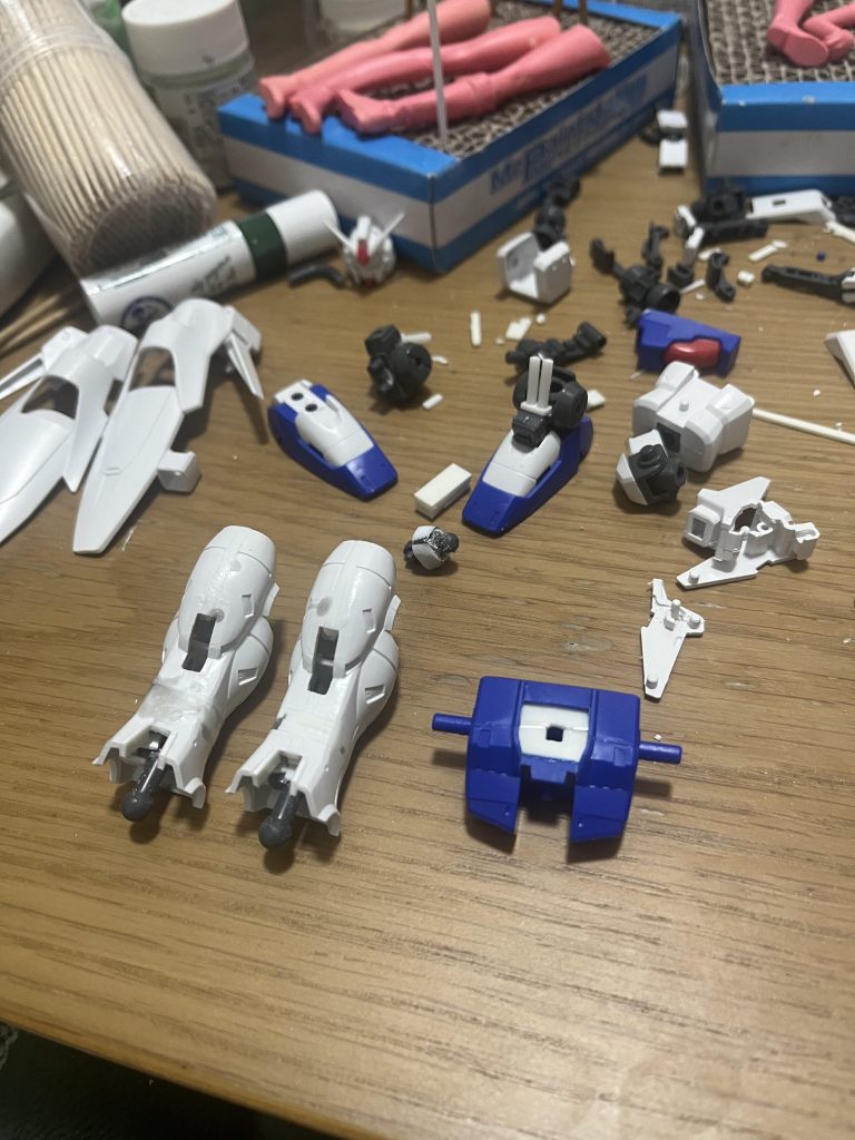 改修パーツまとめ画像。足首の上のシリンダー風ディテールが途中で途切れていたのでプラ棒で延長。可動範囲は狭くなりました。テールバインダーはバーニアが露出するように角度を調節しました。奥に映り込んでいるのはダーティーペア。